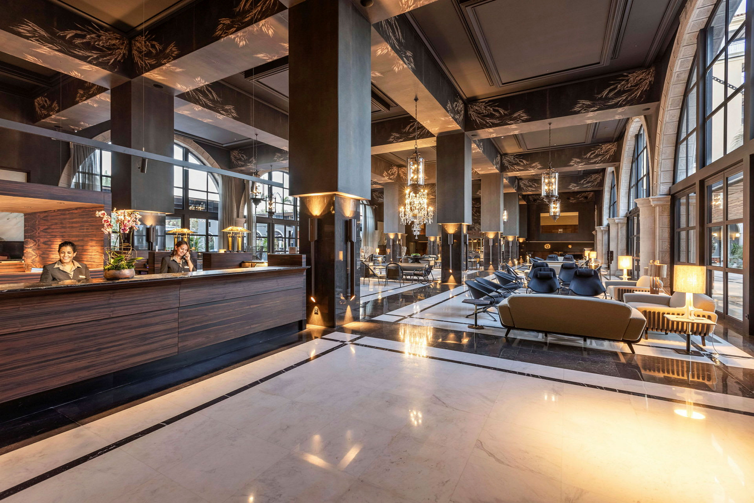 Et hotellobbyområde med elegant innredning, inkludert sofaer og en resepsjonsdisk. (AI-generert tekst)