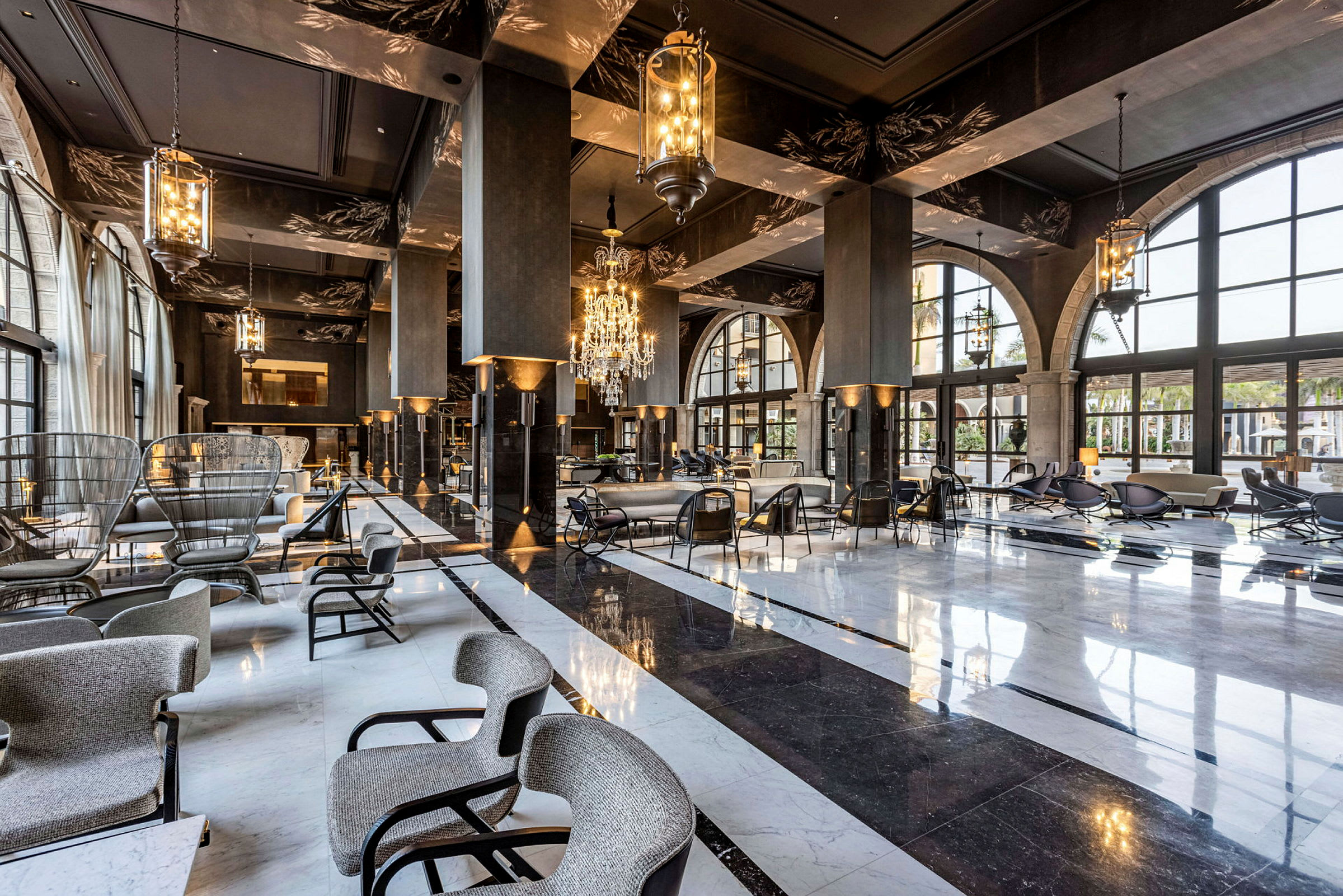 En stor luksuriøs hotellobby med sittegrupper, et blankt marmorbelagt gulv og elegante lysinstallasjoner. (AI-generert tekst)