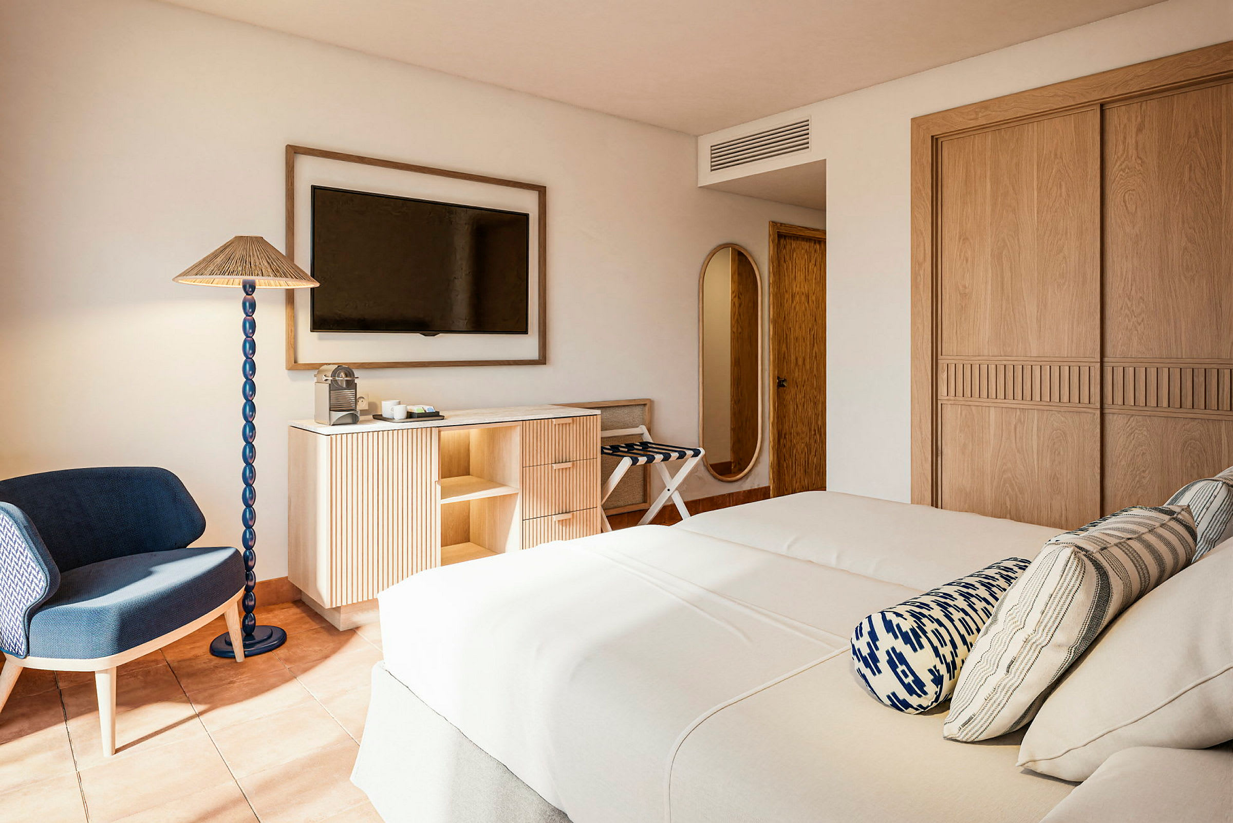 Et hotellrom med to senger, en TV på veggen, et moderne skap og en stol ved siden av en gulvlampe. (AI-generert tekst)