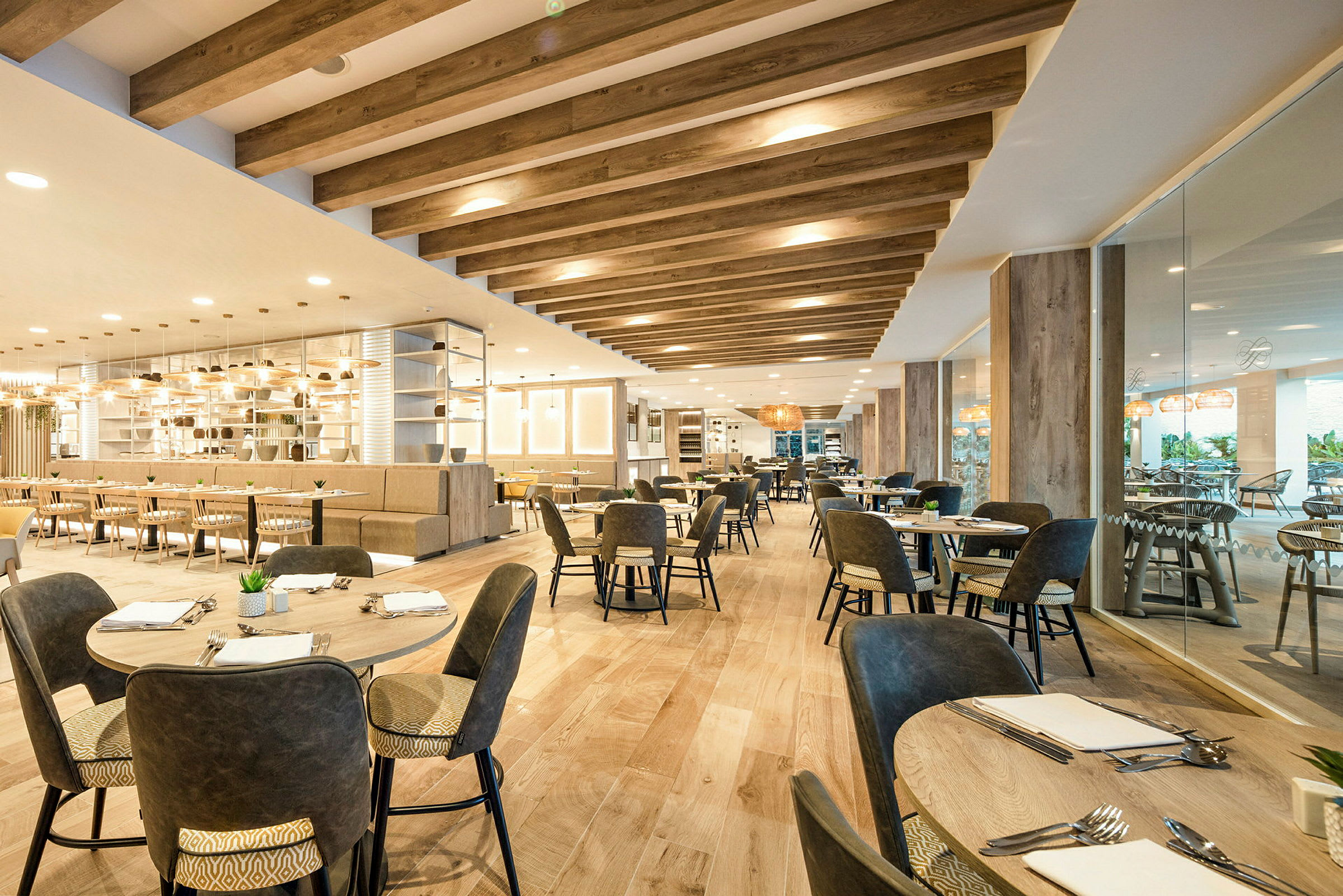 Interiør av en moderne restaurant med bord og stoler, tredetaljer og belysning. (AI-generert tekst)
