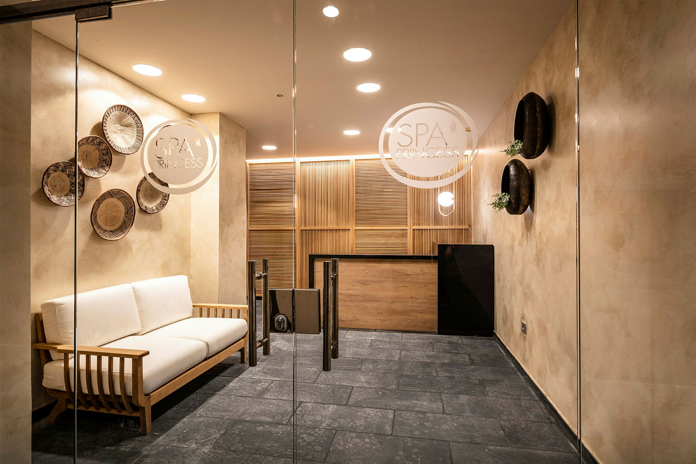 Et moderne spa-mottaksområde med en sofa og dekorative detaljer på veggene. (AI-generert tekst)