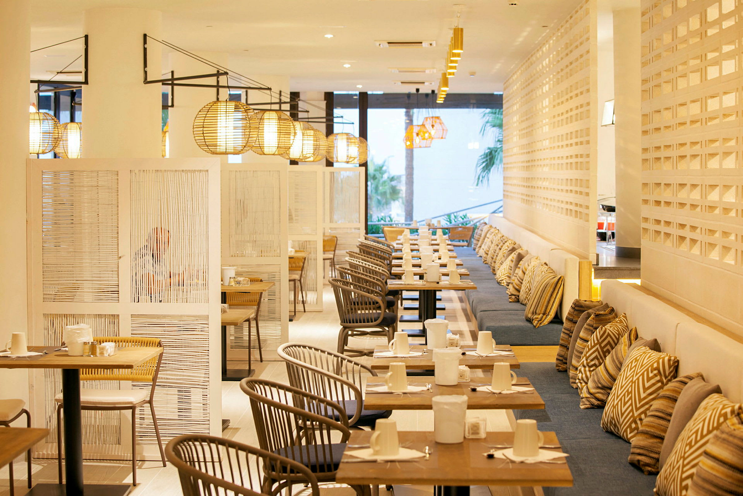 Bilde av en moderne restaurant med bord, stoler og lamper. (AI-generert tekst)