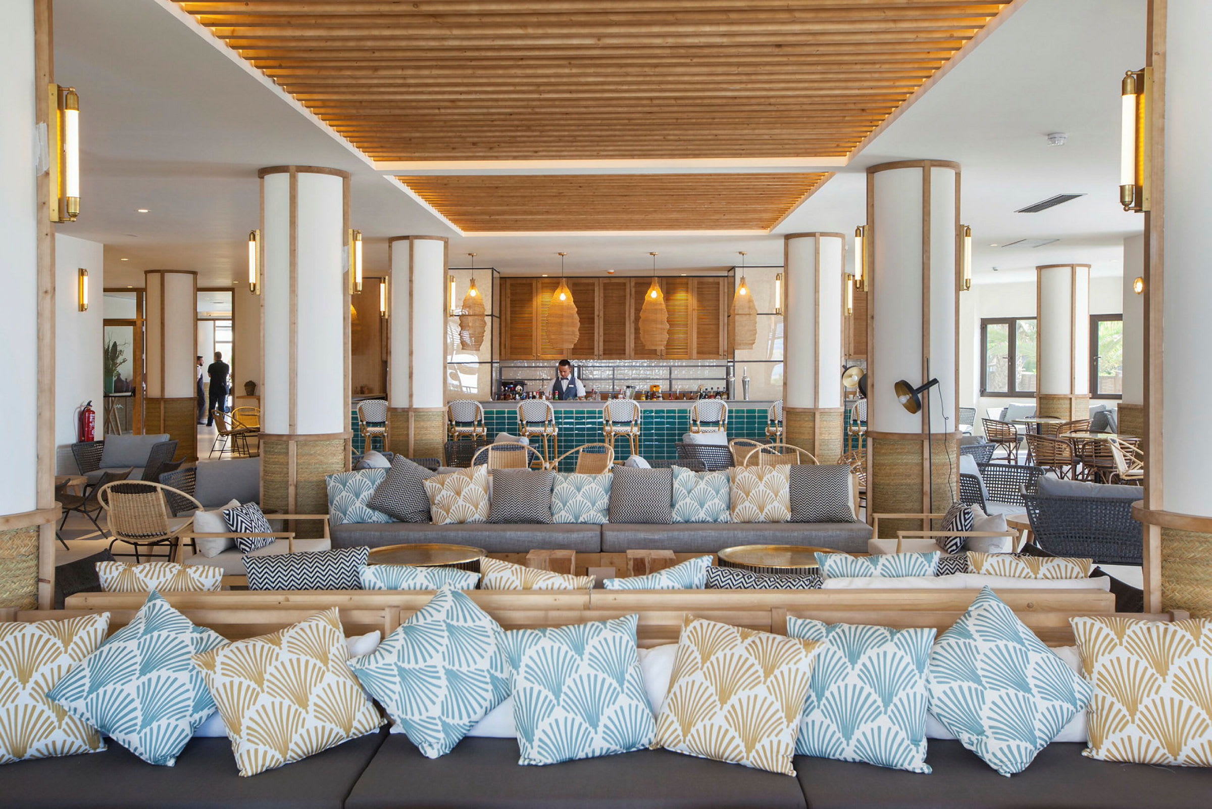 Et moderne loungeområde med sofaer, puter og en bar. (AI-generert tekst)