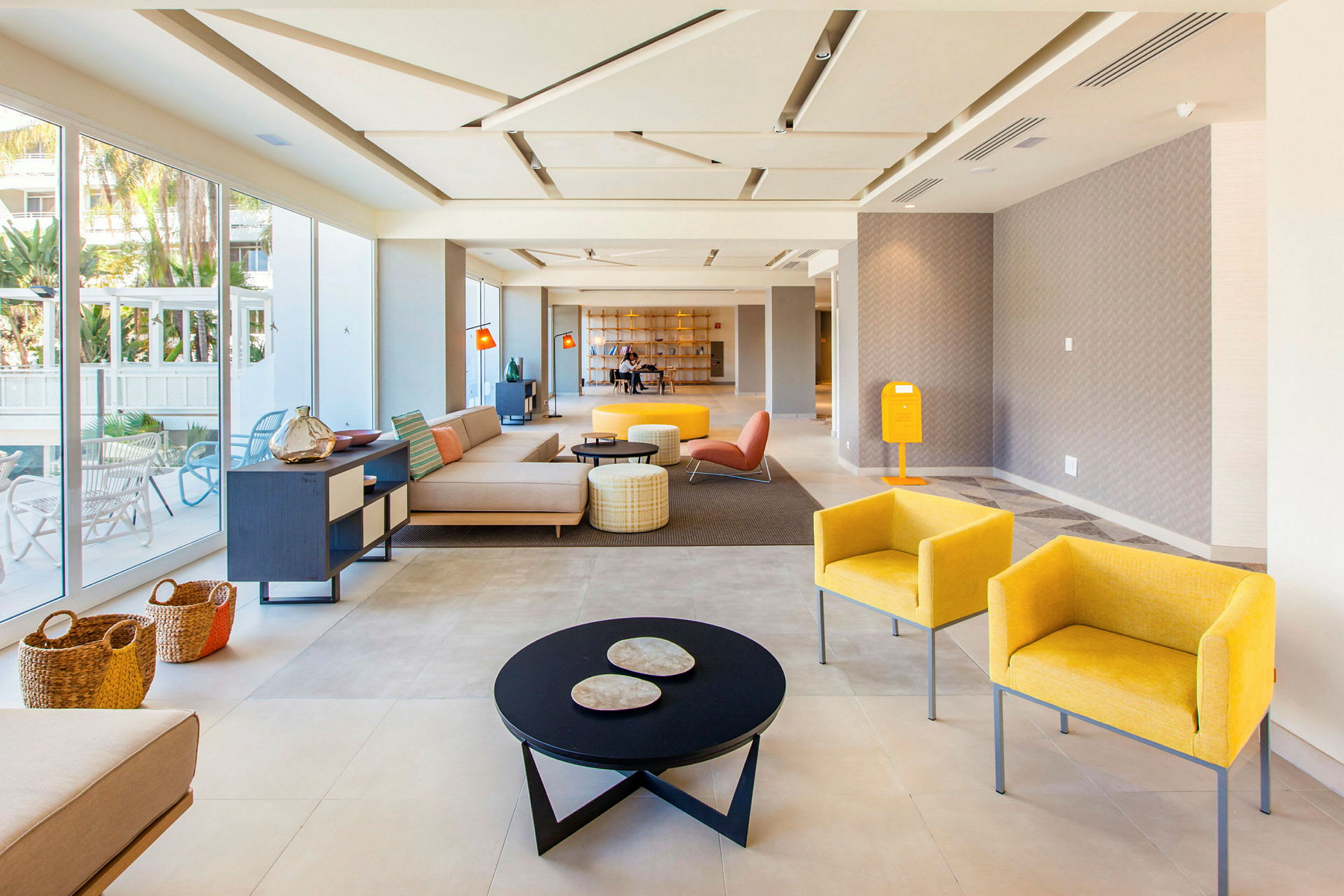 Lys og moderne hotellobby med sittegrupper og glassvegger. (AI-generert tekst)
