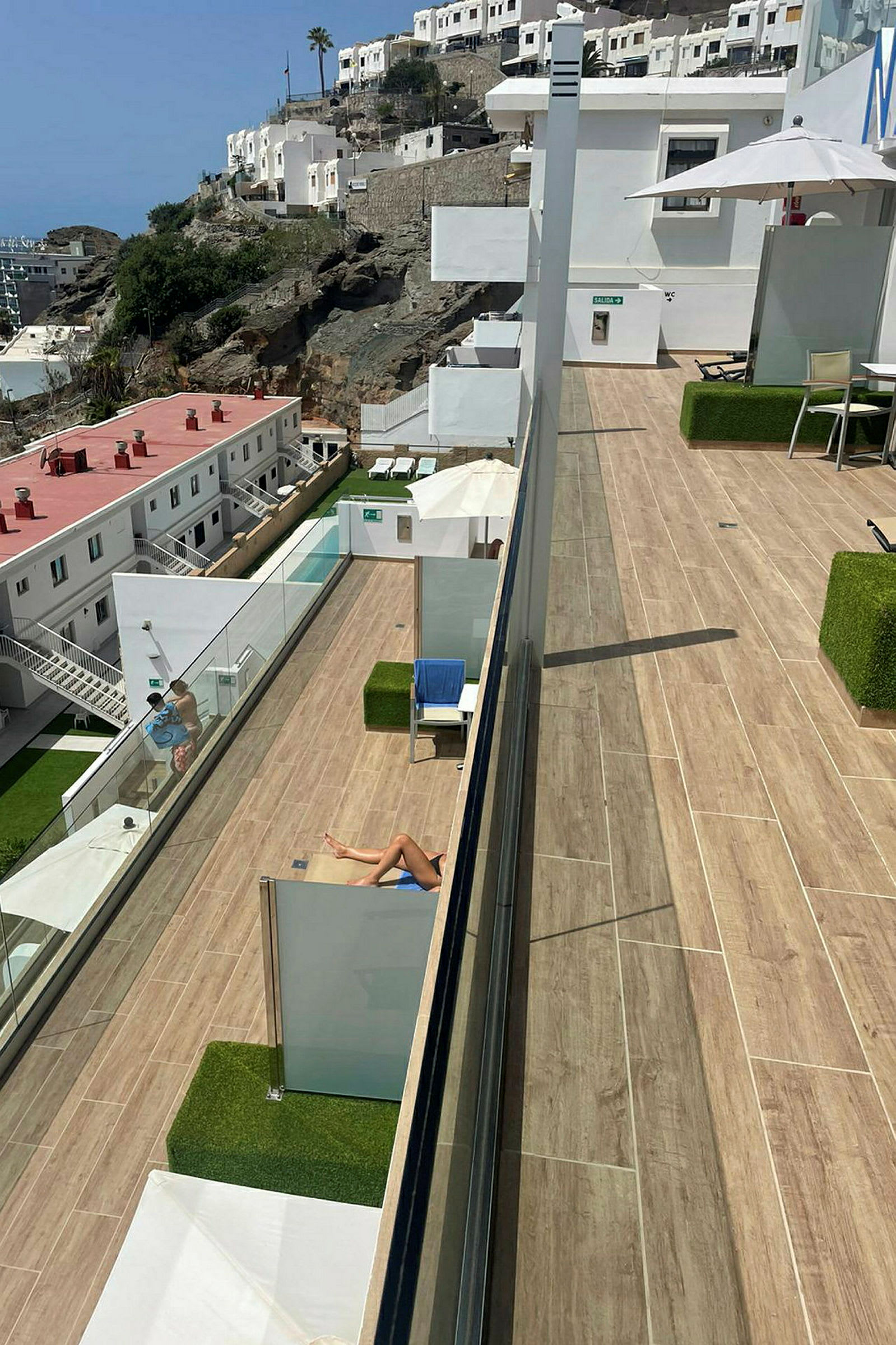 En solterrasse med utsikt over et hotellområde på en fjellside. (AI-generert tekst)