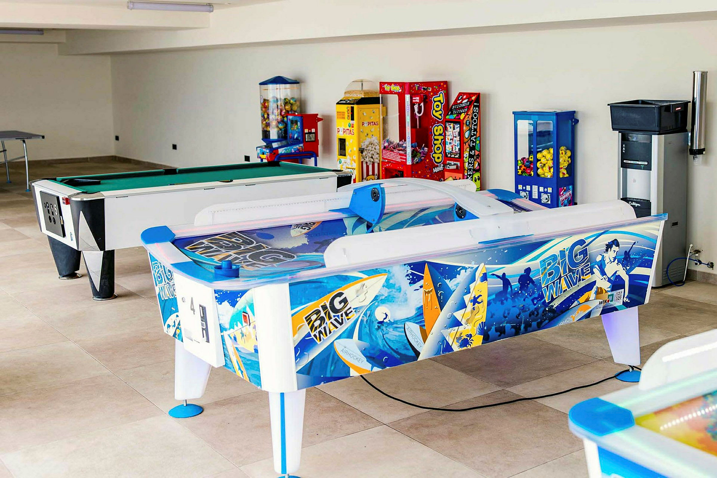 Et spillerom med biljardbord, air hockey og ulike spilleautomater. (AI-generert tekst)