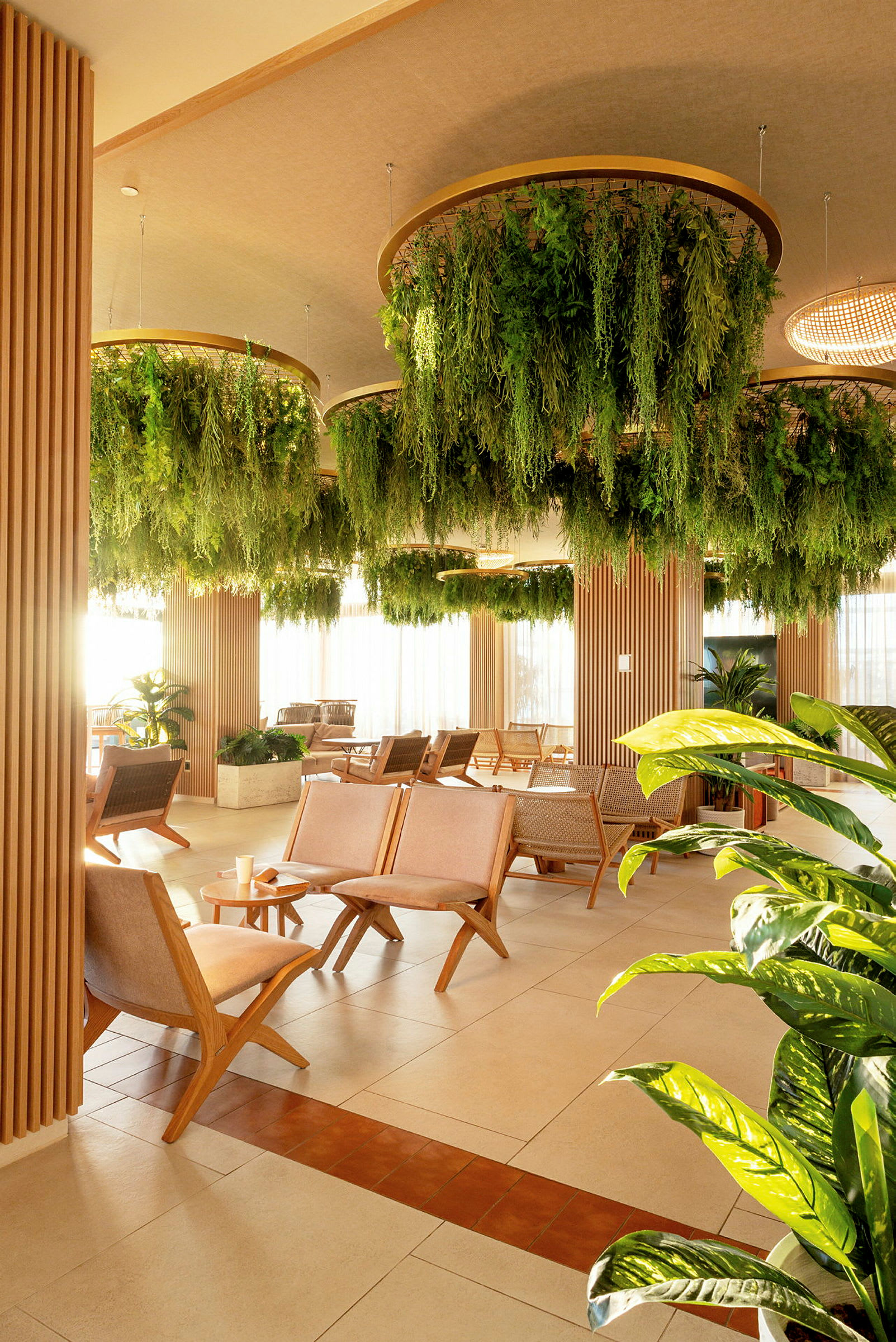 Loungeområde med sittegrupper og hengende plantedekorasjoner i taket. (AI-generert tekst)