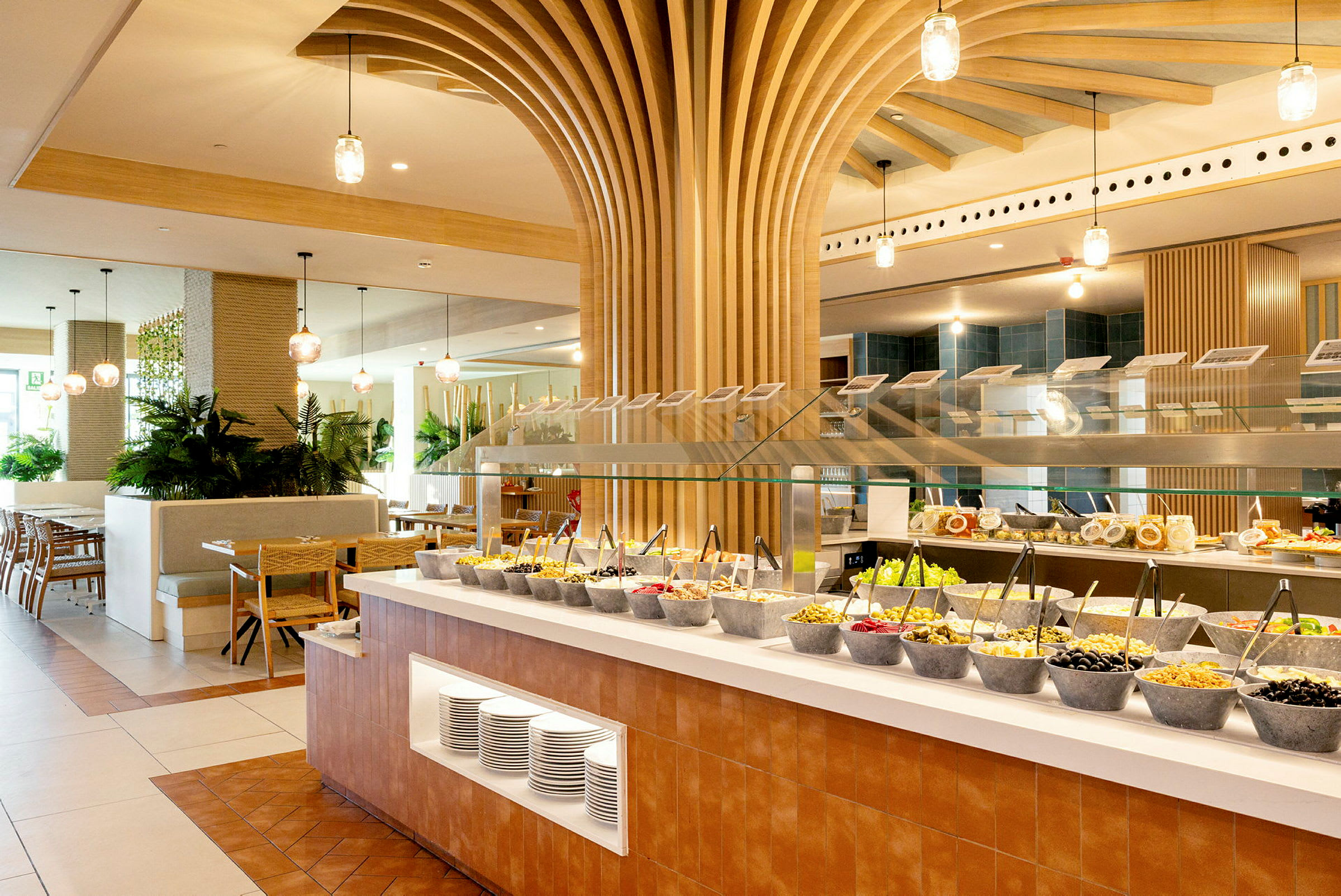 En restaurantbuffet med forskjellige boller med salatingredienser og et moderne innredet rom. (AI-generert tekst)