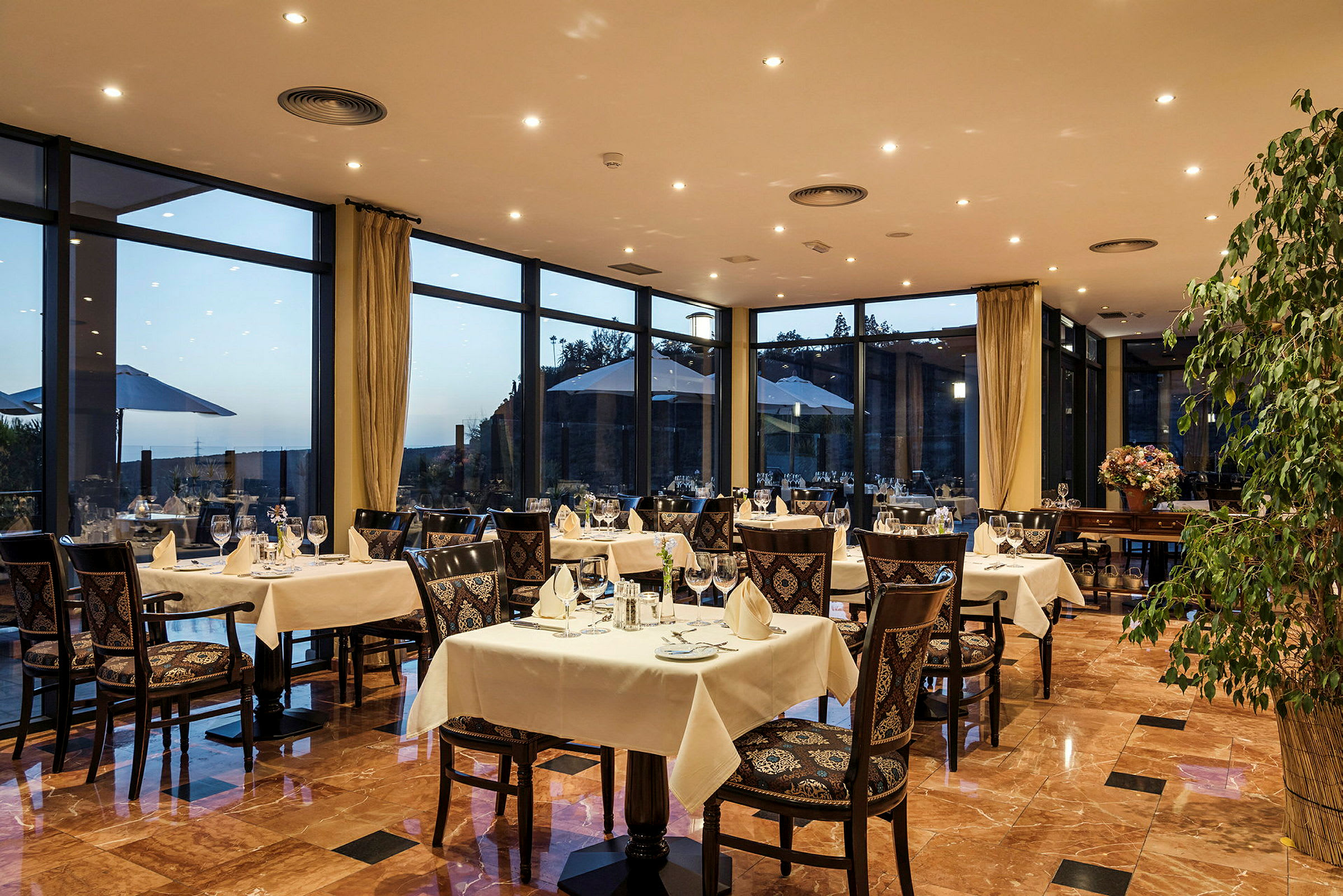 Restaurant med dekorerte bord og utsikt gjennom store vinduer. (AI-generert tekst)
