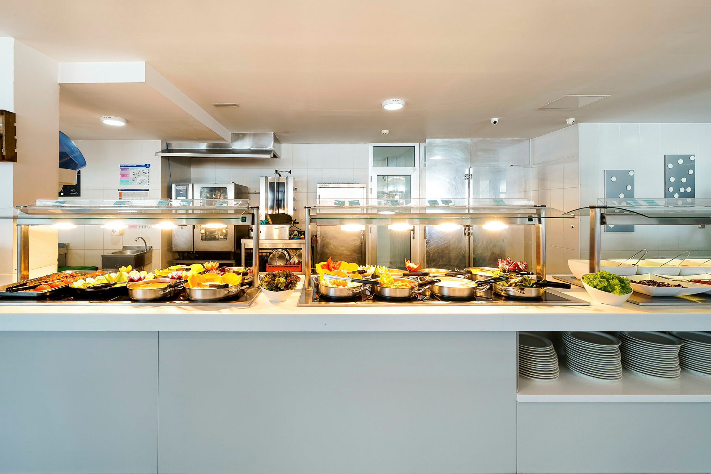 Buffetbord med ulike retter og salater i en lys serveringsmiljø. (AI-generert tekst)