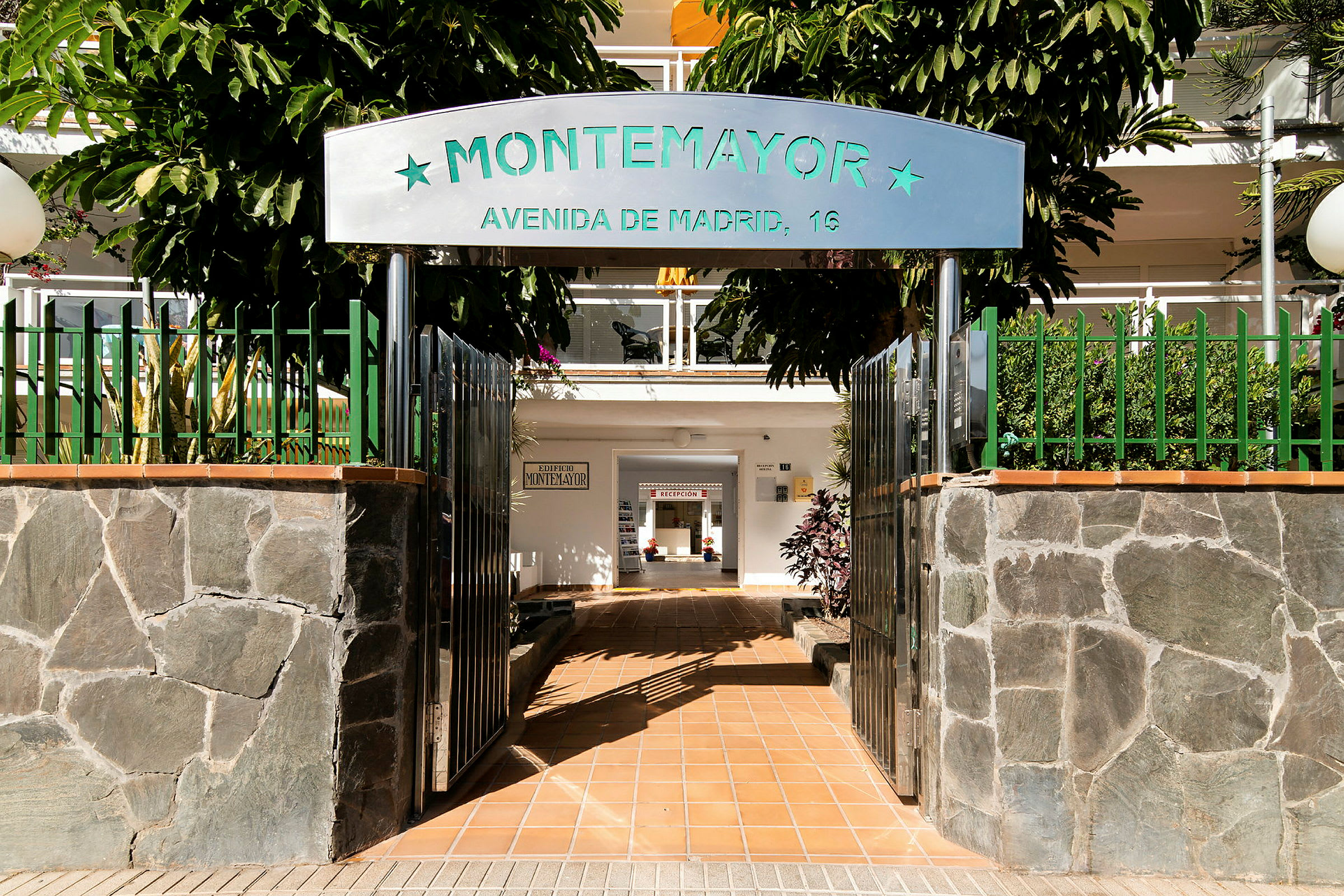 Inngang til bygning med skiltet 'Montemayor' og en gangvei innendørs. (AI-generert tekst)