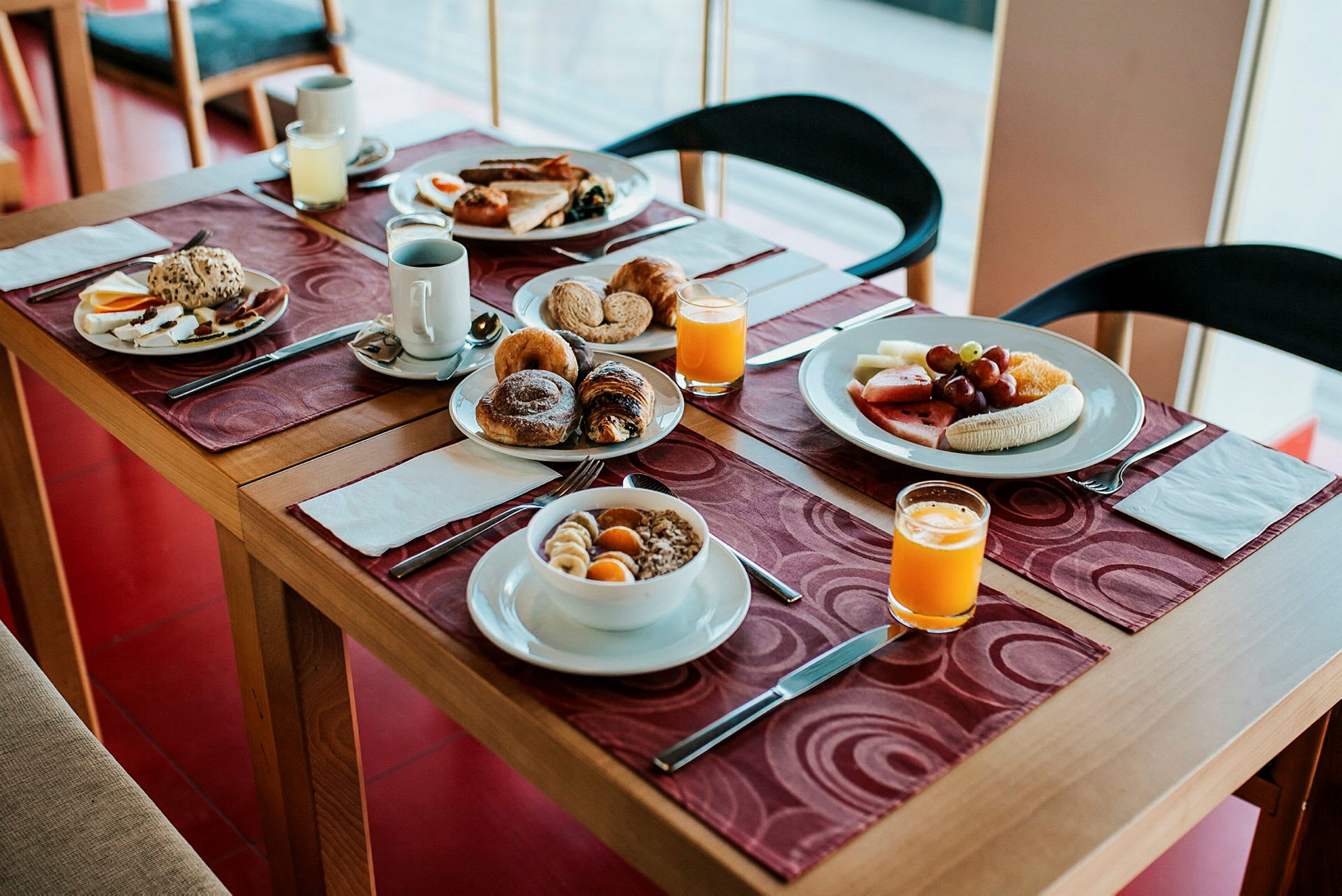 Frokostbord med brød, frukt, juice og ulike måltider. (AI-generert tekst)