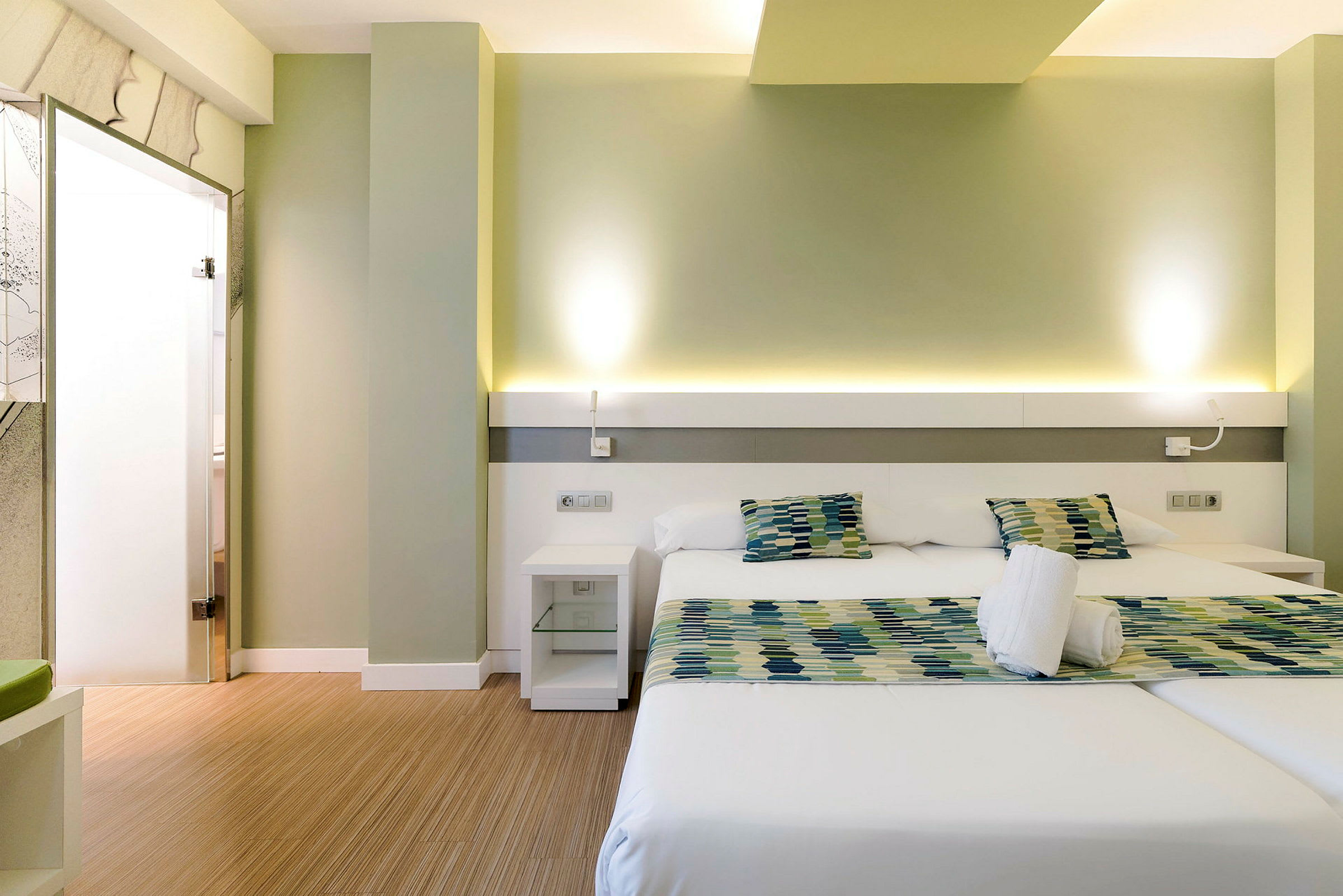 Moderne hotellrom med to enkeltsenger og sittegruppe. (AI-generert tekst)