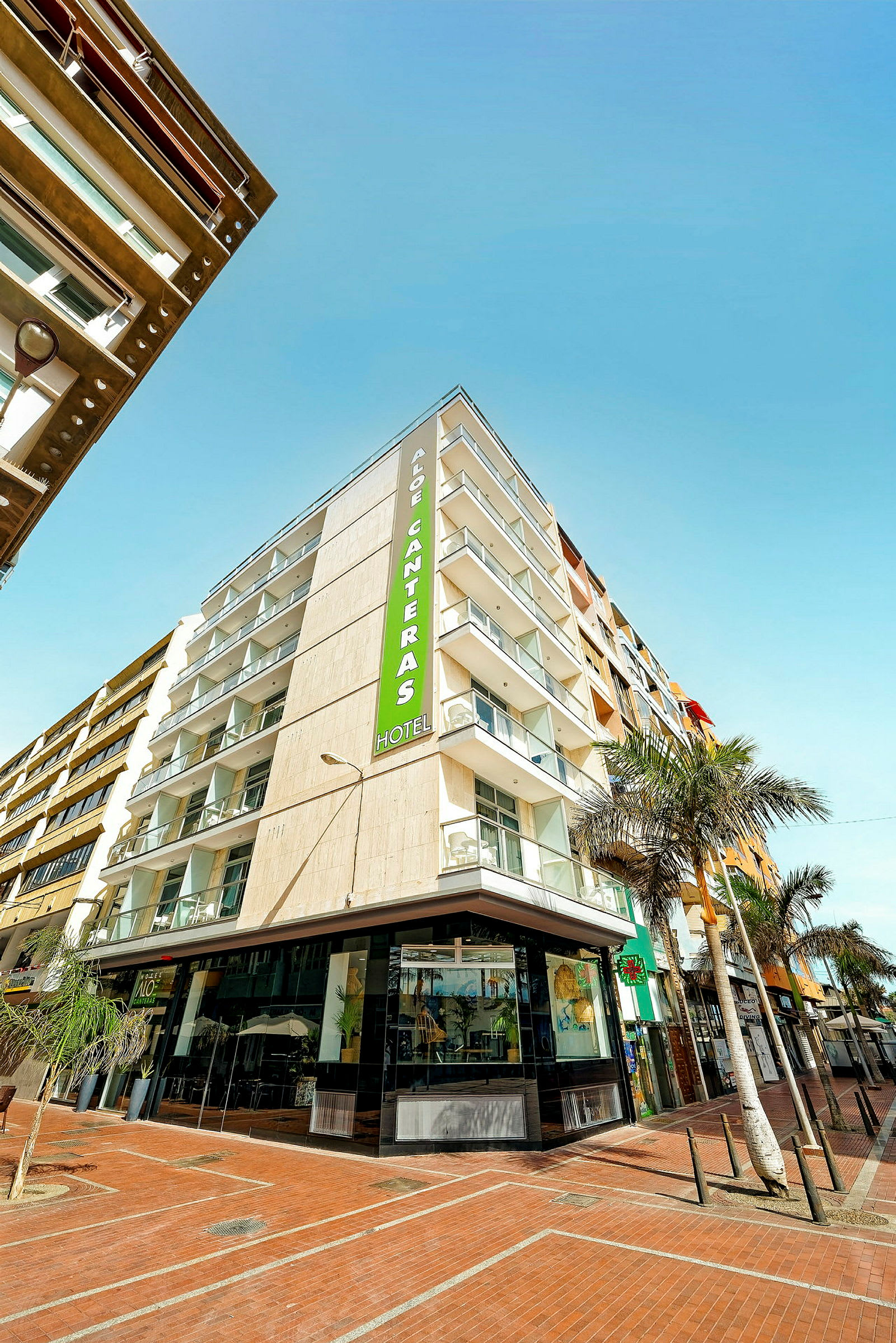 Et moderne hotell med balkonger og et skilt som viser navnet Aloe Canteras. (AI-generert tekst)