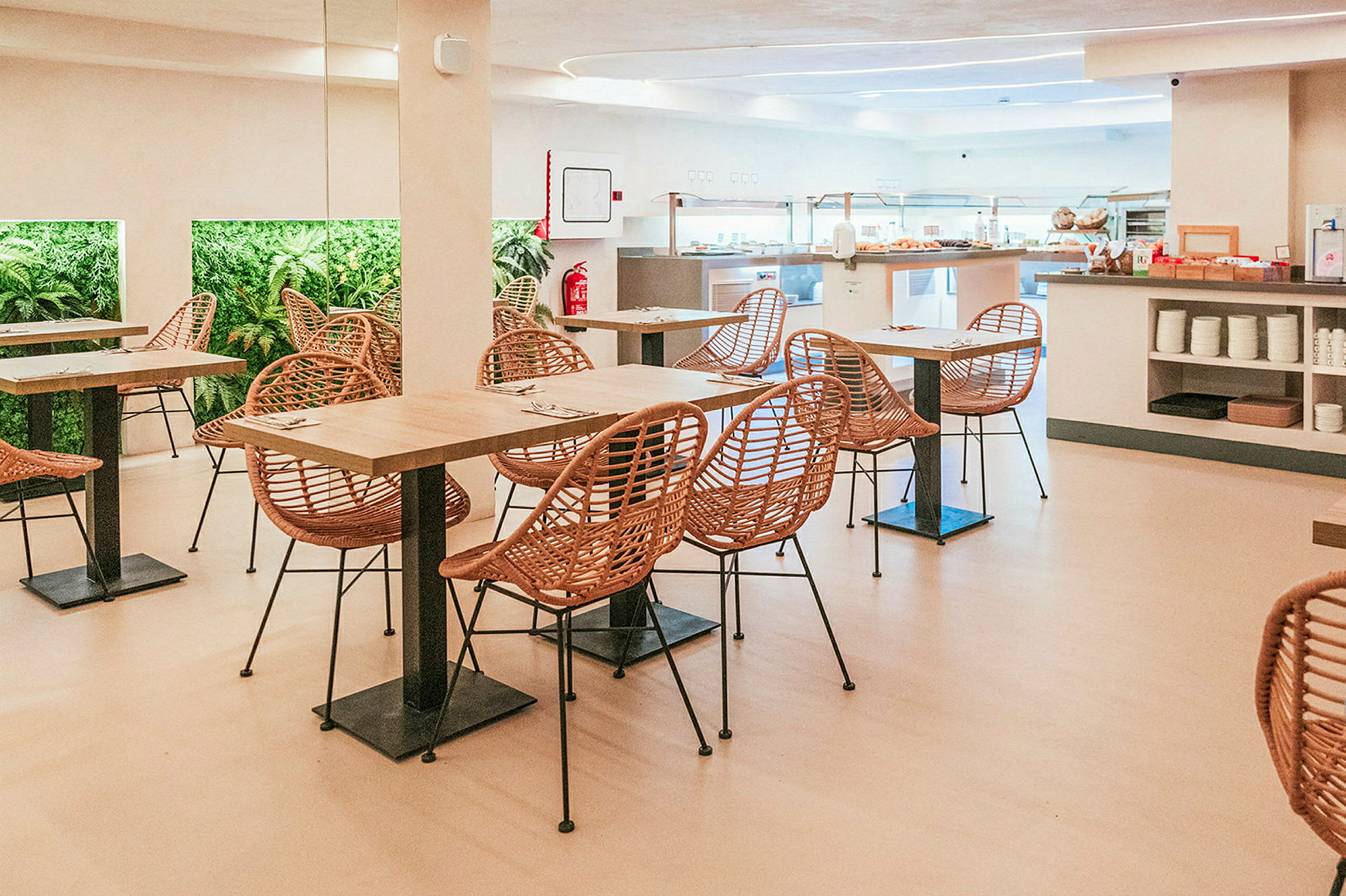 Bilde av en spisesal med bord, stoler og planter på veggen. (AI-generert tekst)