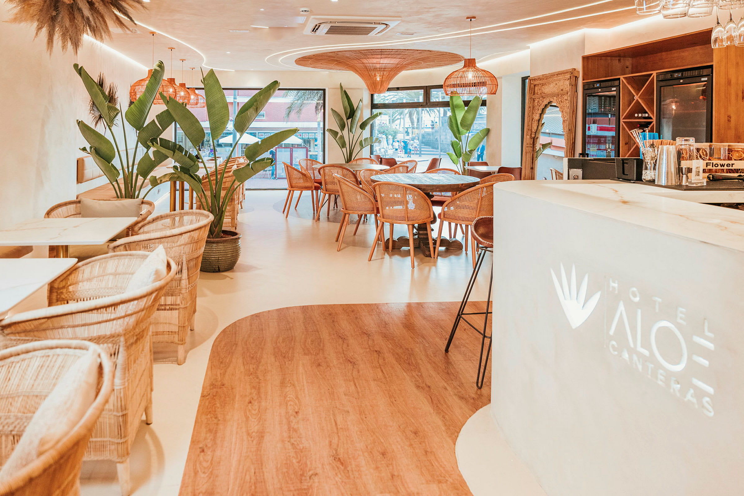 Hotelrestaurant med moderne innredning og store planter. (AI-generert tekst)