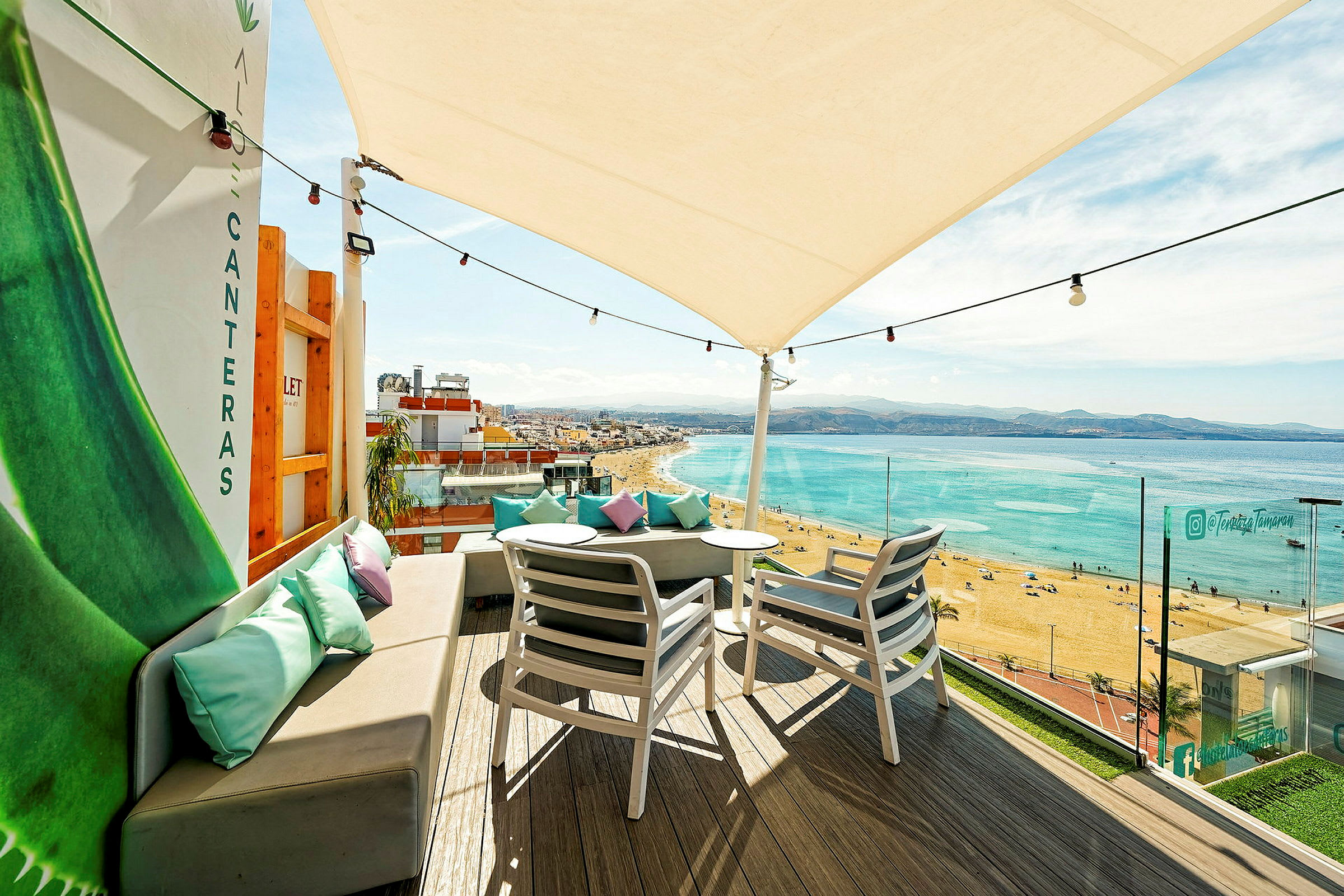 Terrasse med sitteplasser og utsikt over stranden og havet. (AI-generert tekst)