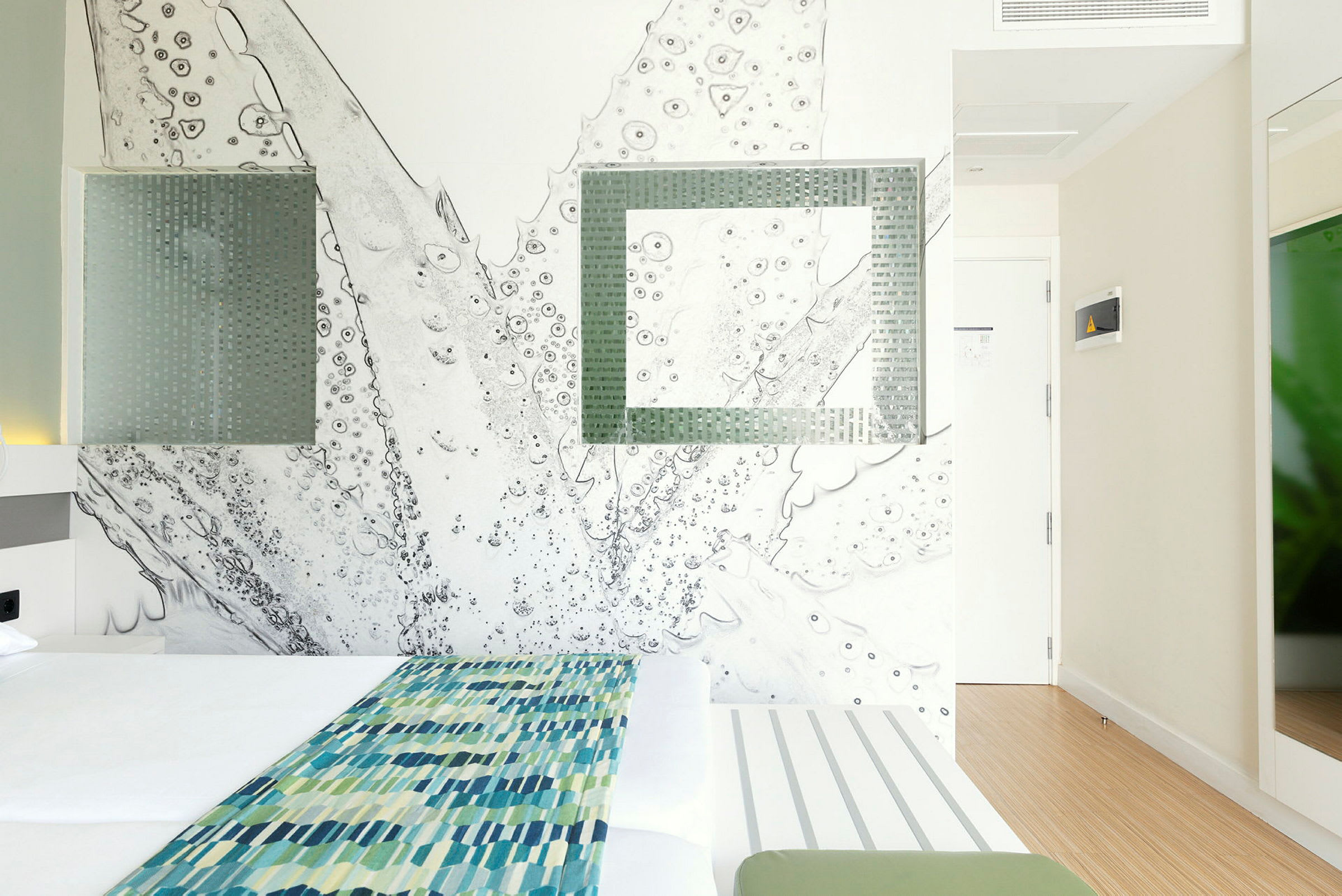 Moderne designet hotellrom med en dobbeltseng og abstrakt veggkunst. (AI-generert tekst)