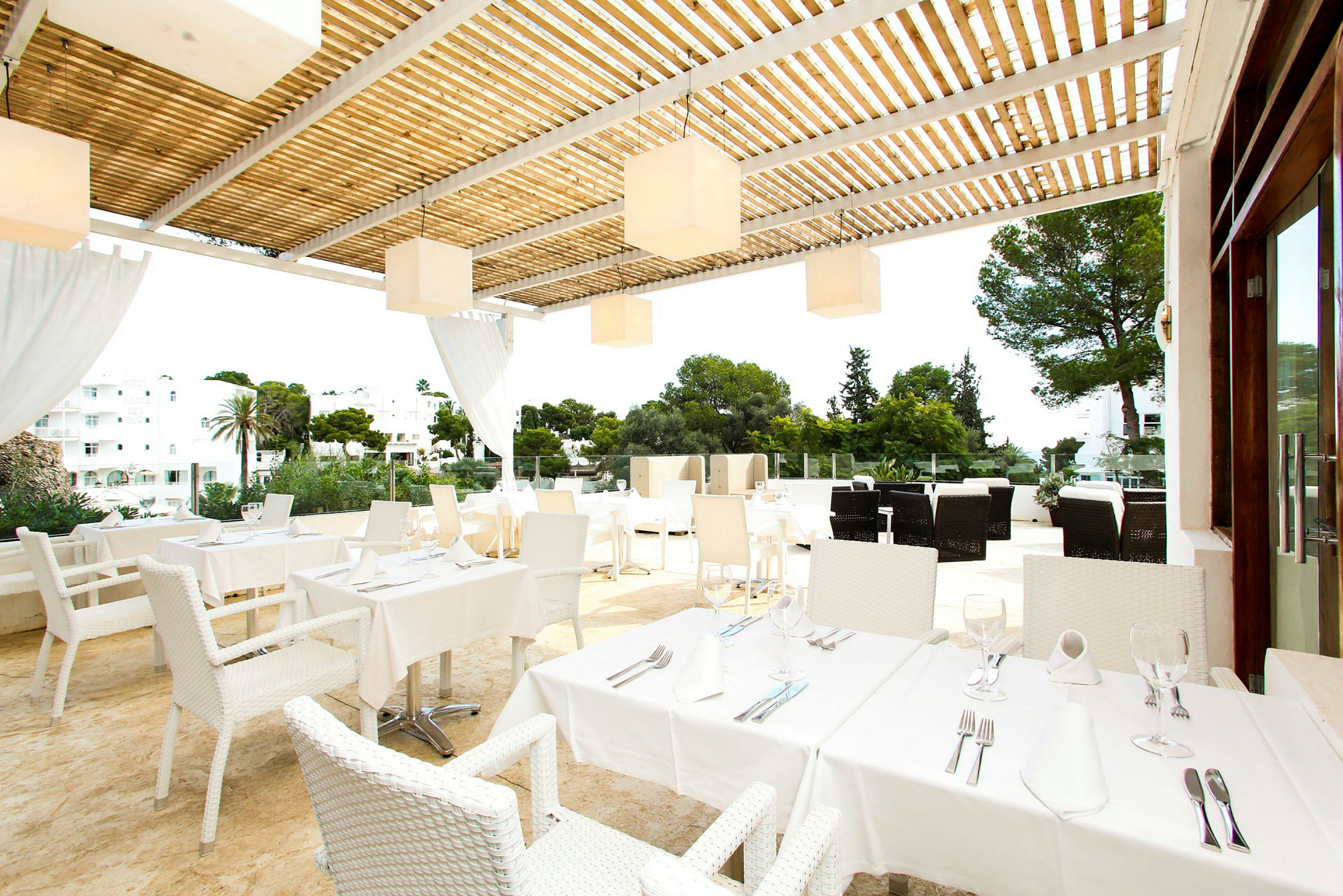 En terrasse med bord og stoler, dekket for måltid, under en pergola. (AI-generert tekst)