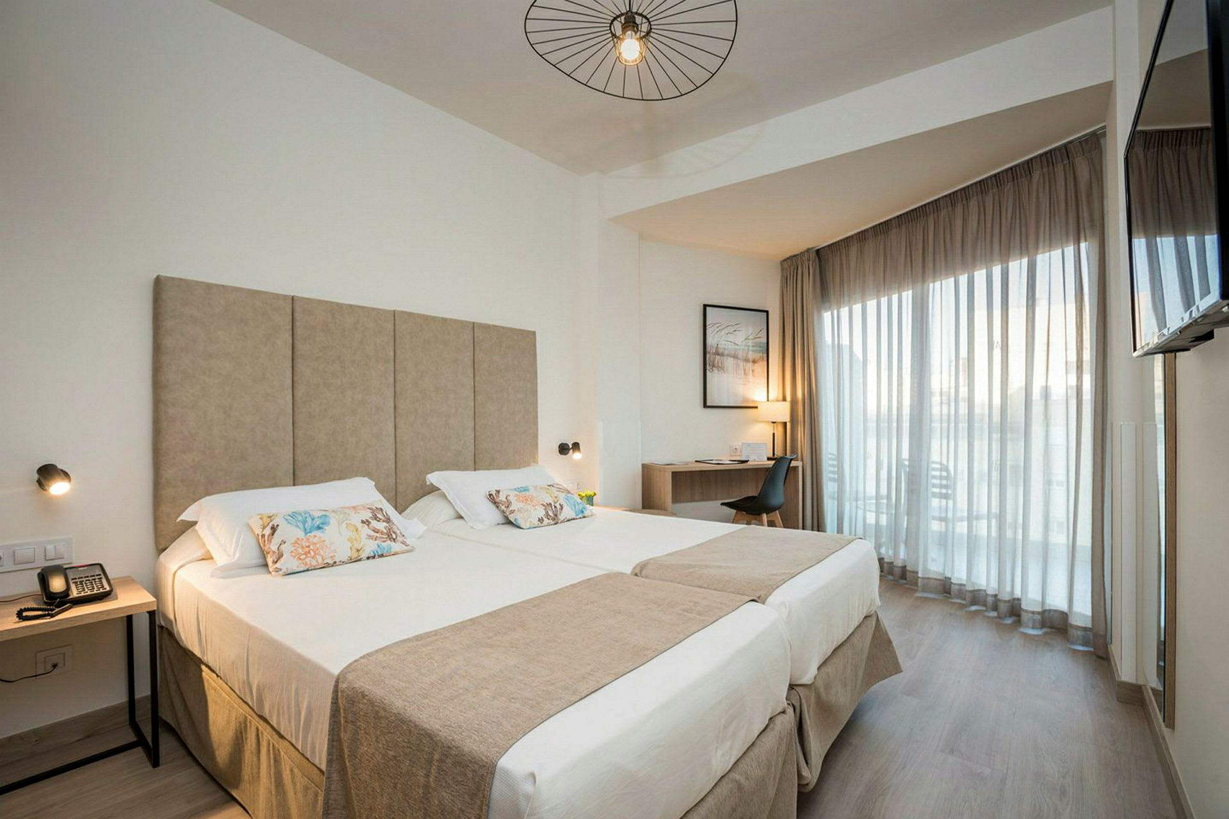 Moderne hotellrom med dobbeltseng, skrivebord og balkong. (AI-generert tekst)