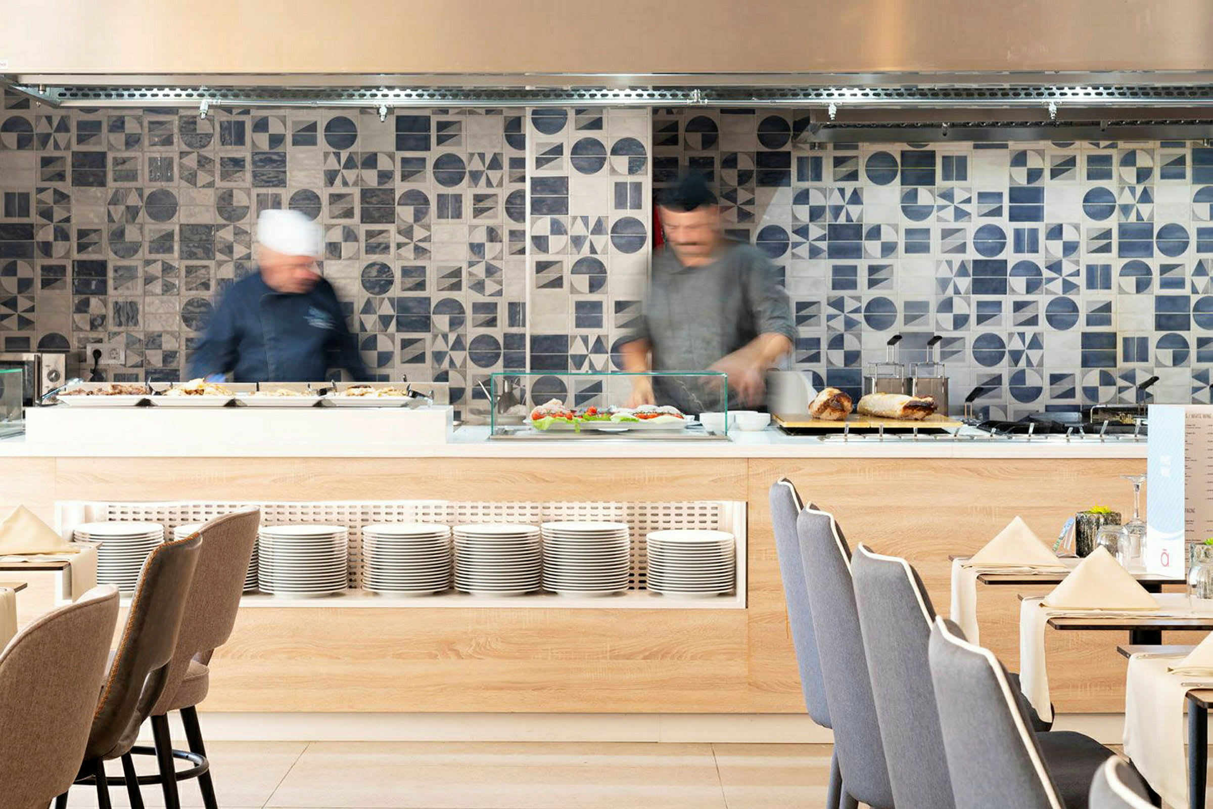 Bufféområde i restaurant med flislagte vegger og tallerkener. (AI-generert tekst)