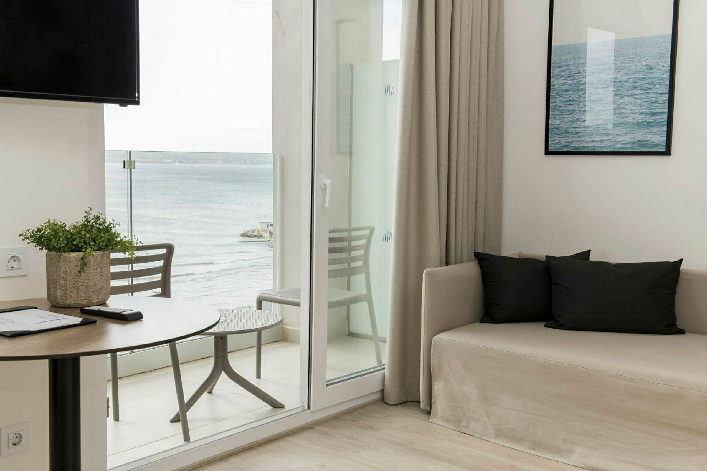Et rom med sofa, bord og utsikt mot havet. (AI-generert tekst)