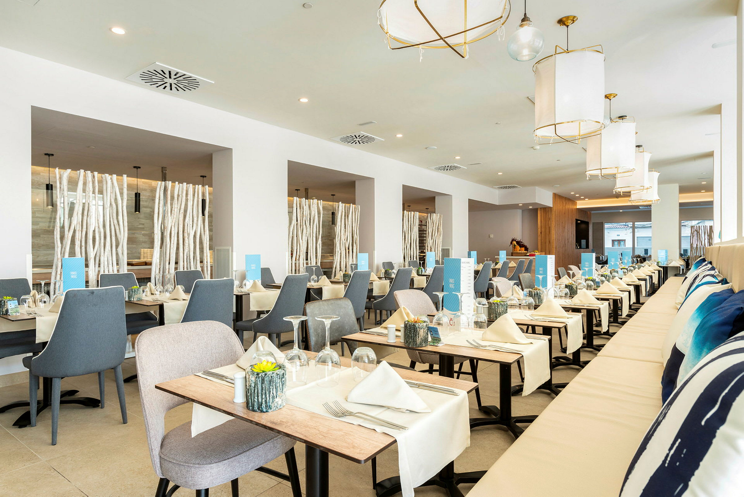 Lys og moderne restaurant med bord dekket med duker og servietter. (AI-generert tekst)