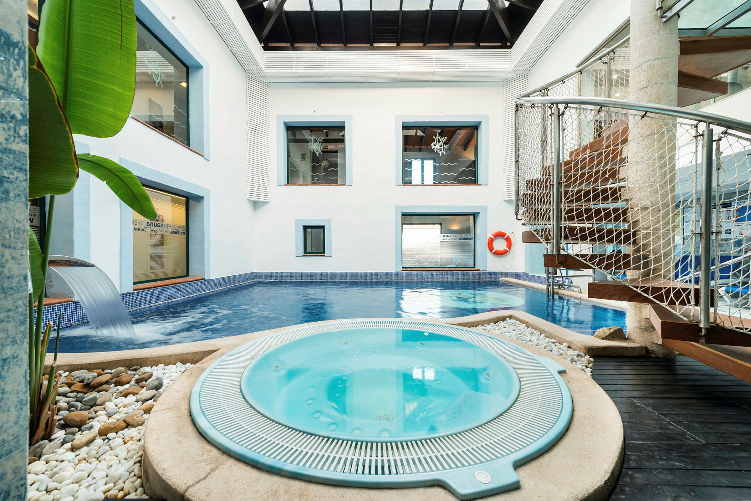 Innendørs spa med basseng og jacuzzi omgitt av moderne detaljer. (AI-generert tekst)