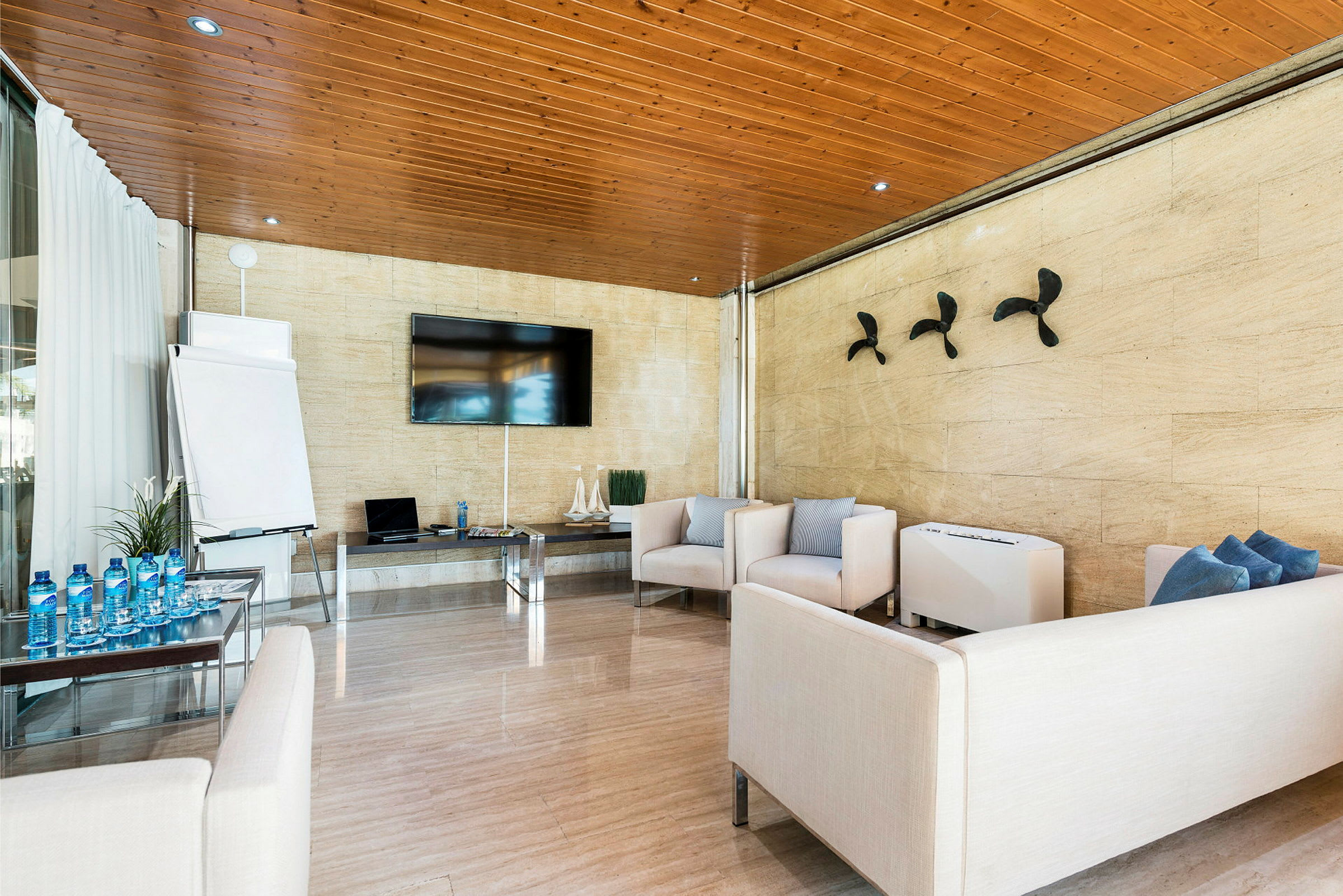 Et moderne møterom med sofaer, et bord, en stor TV og en flip-over. (AI-generert tekst)