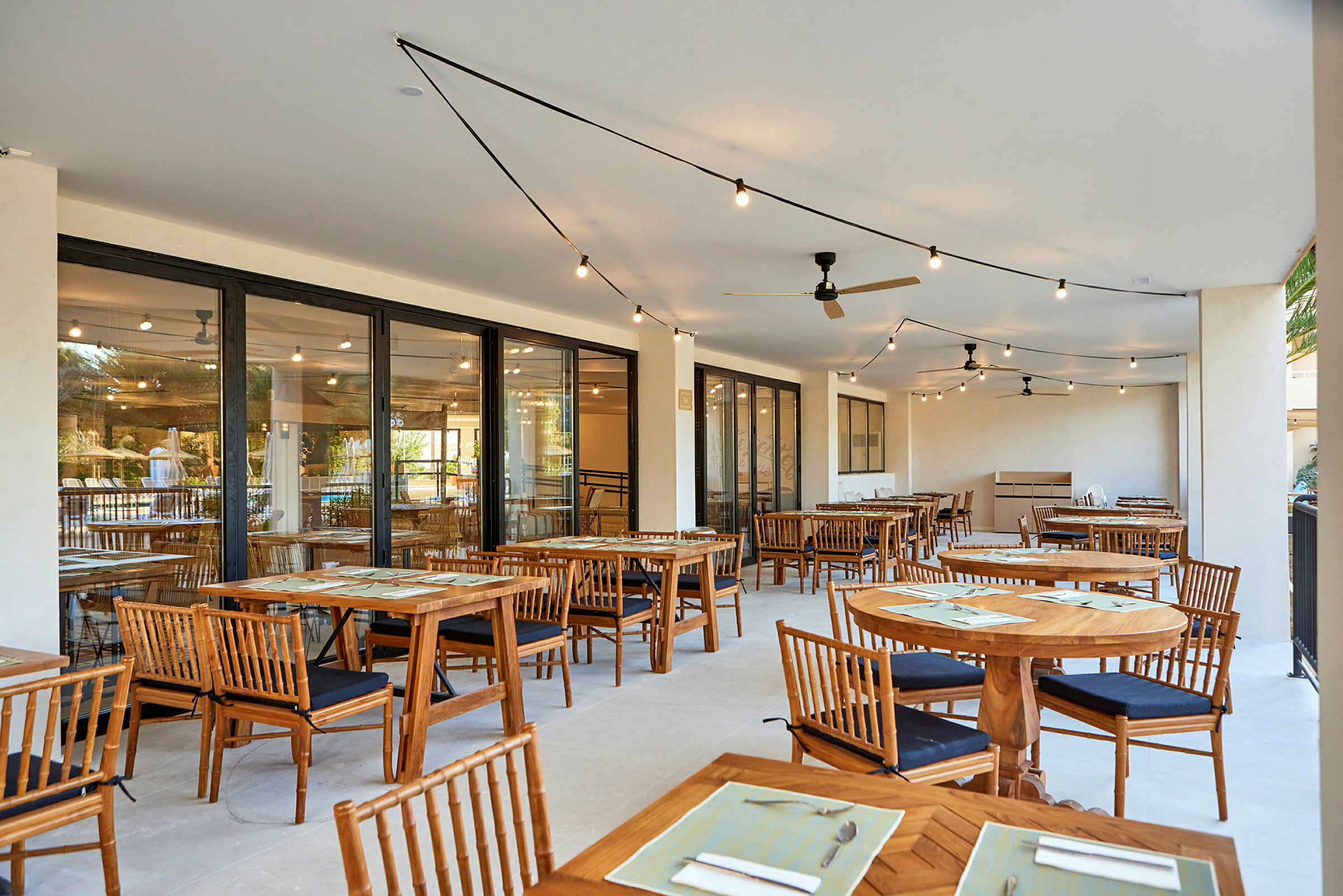 Utendørsrestaurant med bord og stoler av tre. (AI-generert tekst)
