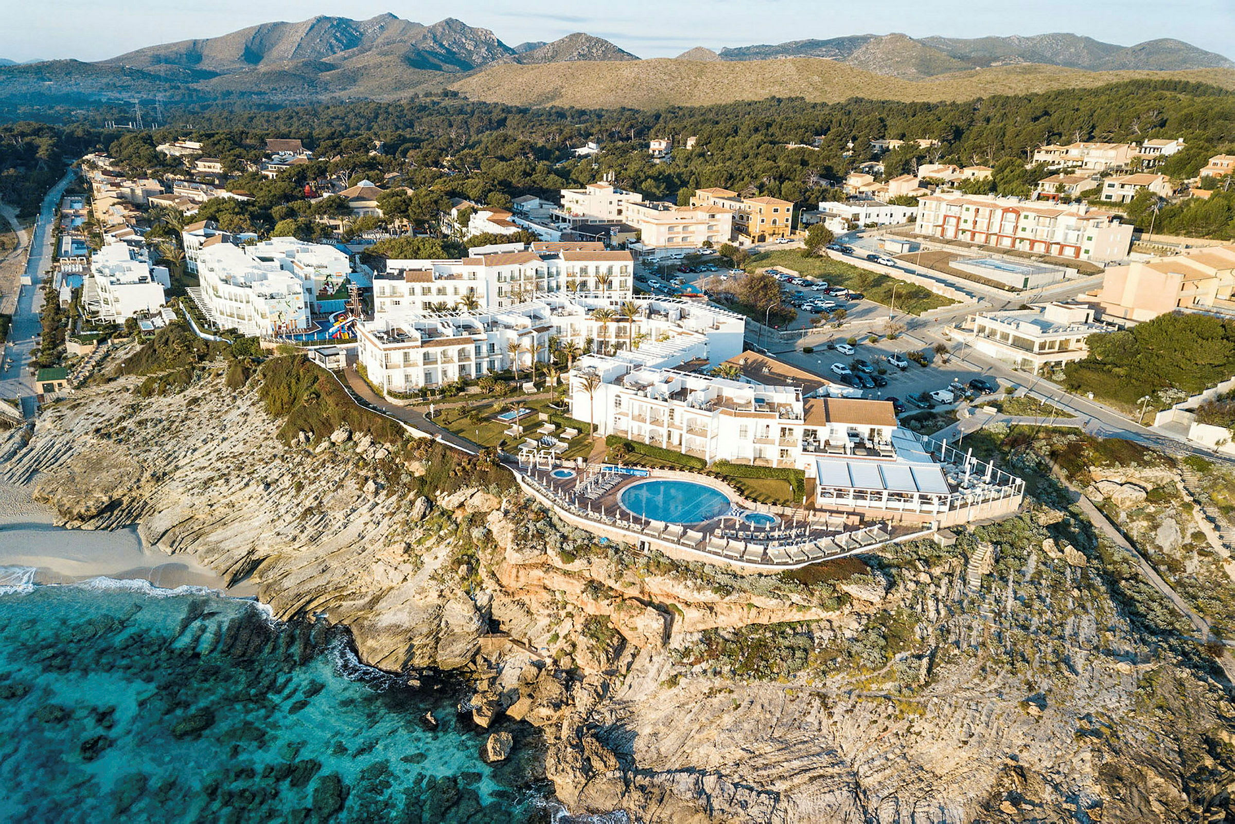 Luftfoto av et hotell på en klippe med basseng og utsikt over havet. (AI-generert tekst)