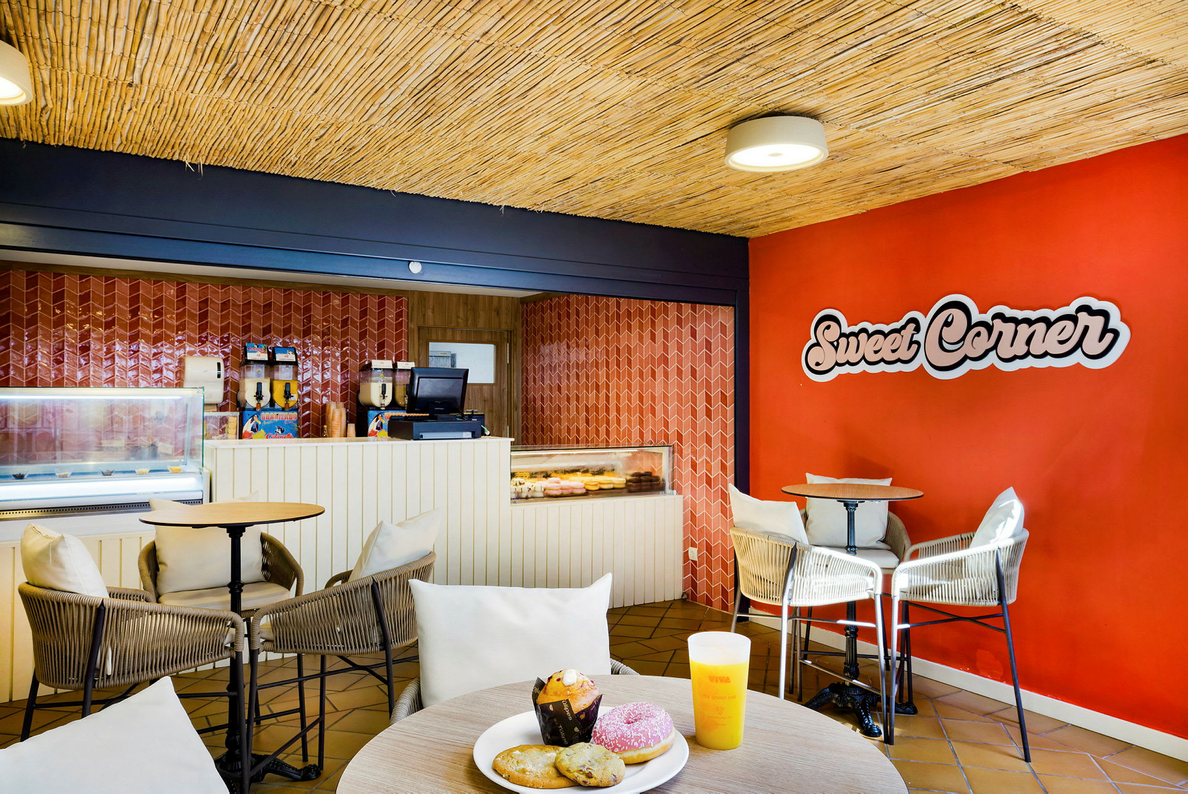 En kafé med bord og sitteplasser, samt en disk med bakverk og drikke. (AI-generert tekst)