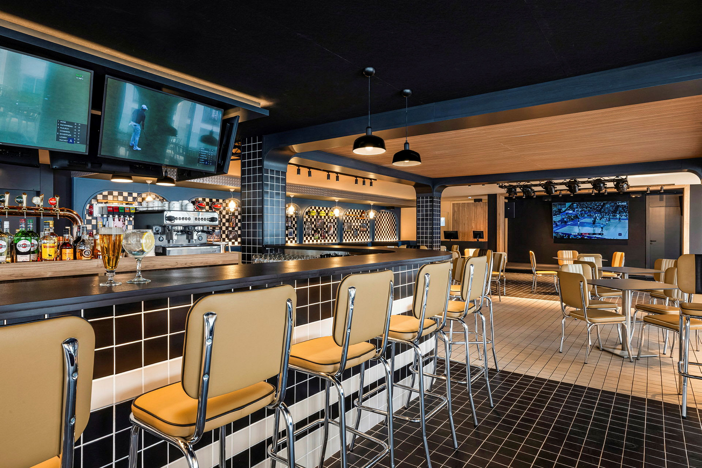 Innredning av en moderne bar med barstoler, bord og en TV på veggen. (AI-generert tekst)