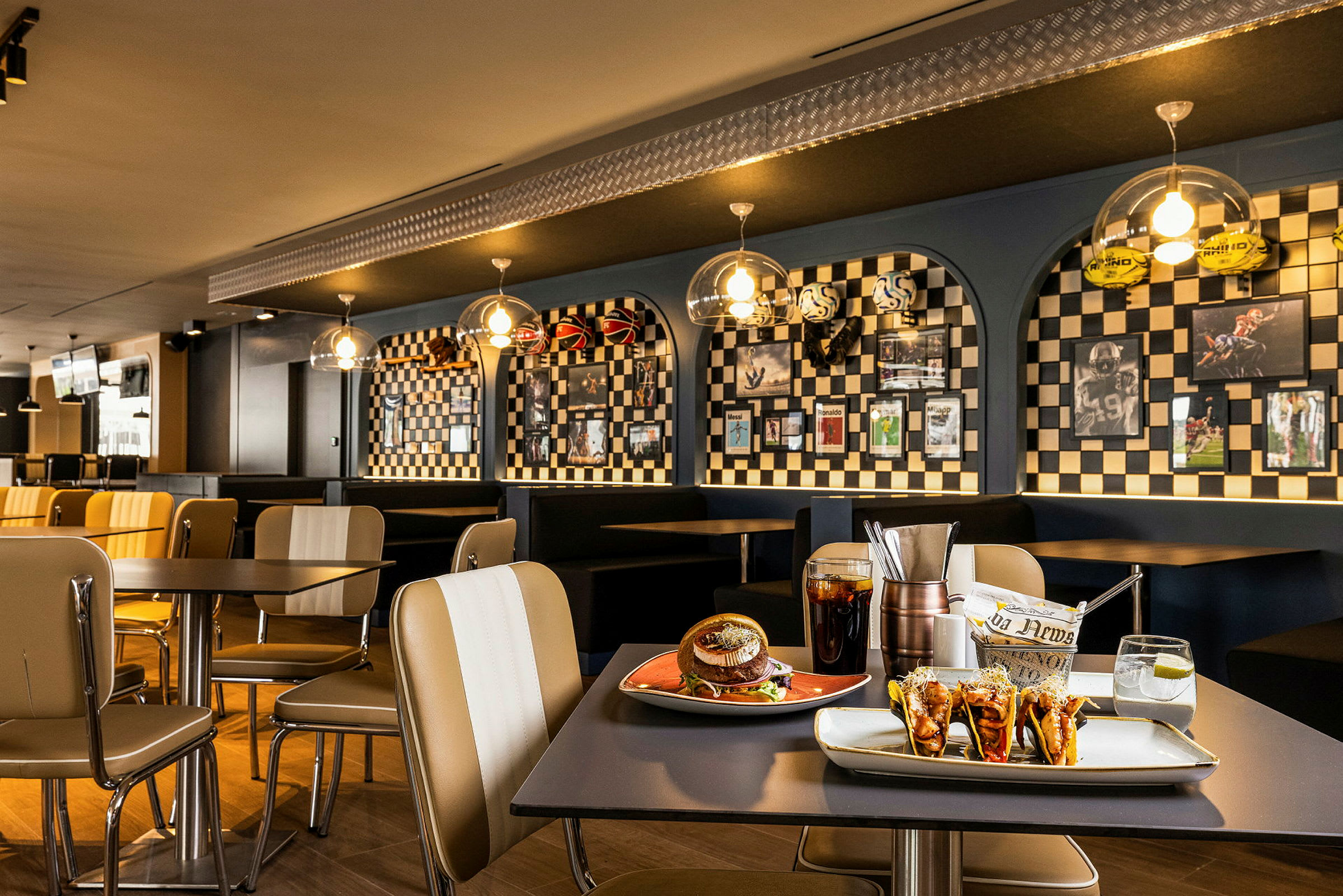 Interiørbilde av en restaurant med bord, stoler og dekorert vegg. (AI-generert tekst)