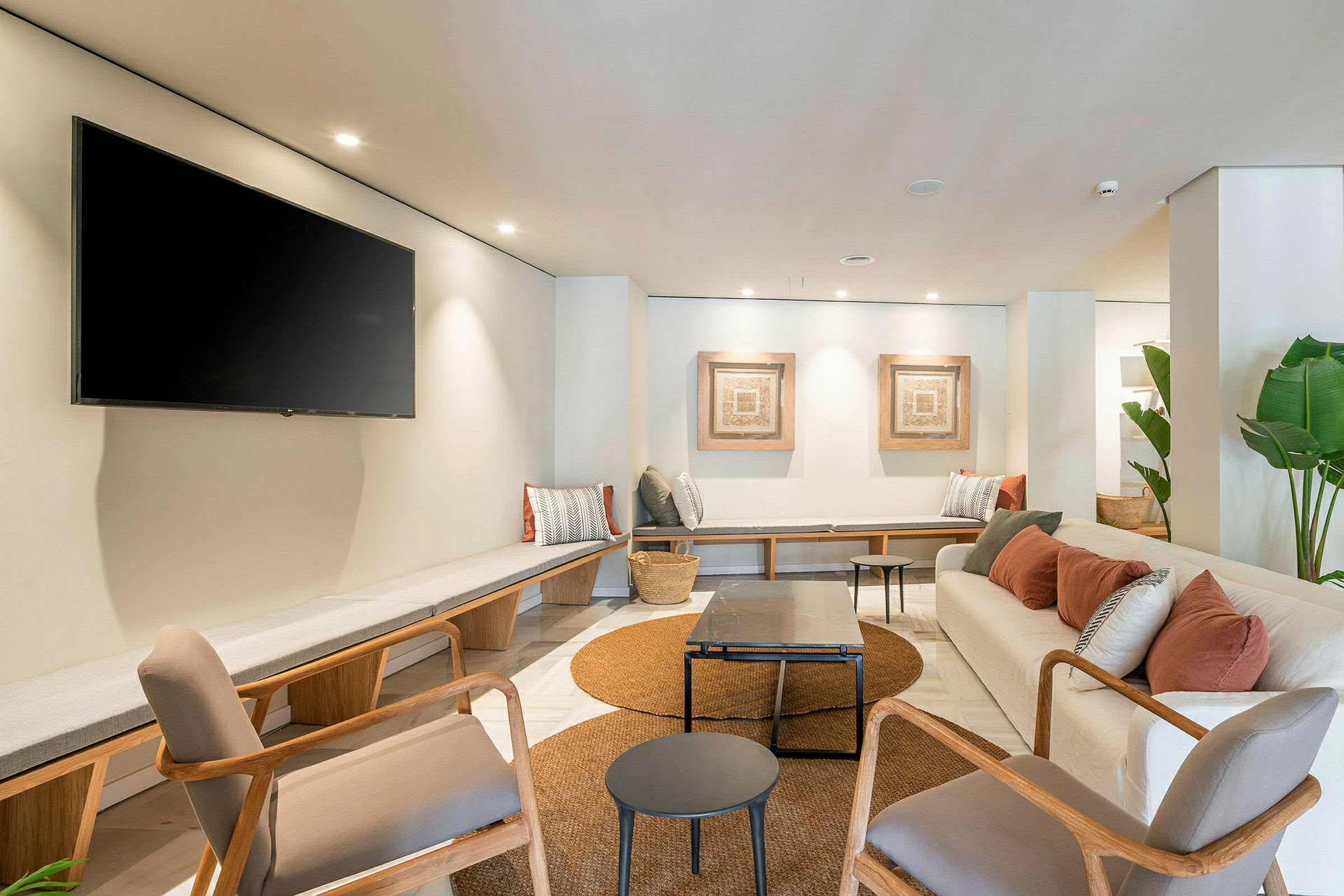 Moderne møblert lounge med sitteplasser, bord og veggdekorasjoner. (AI-generert tekst)