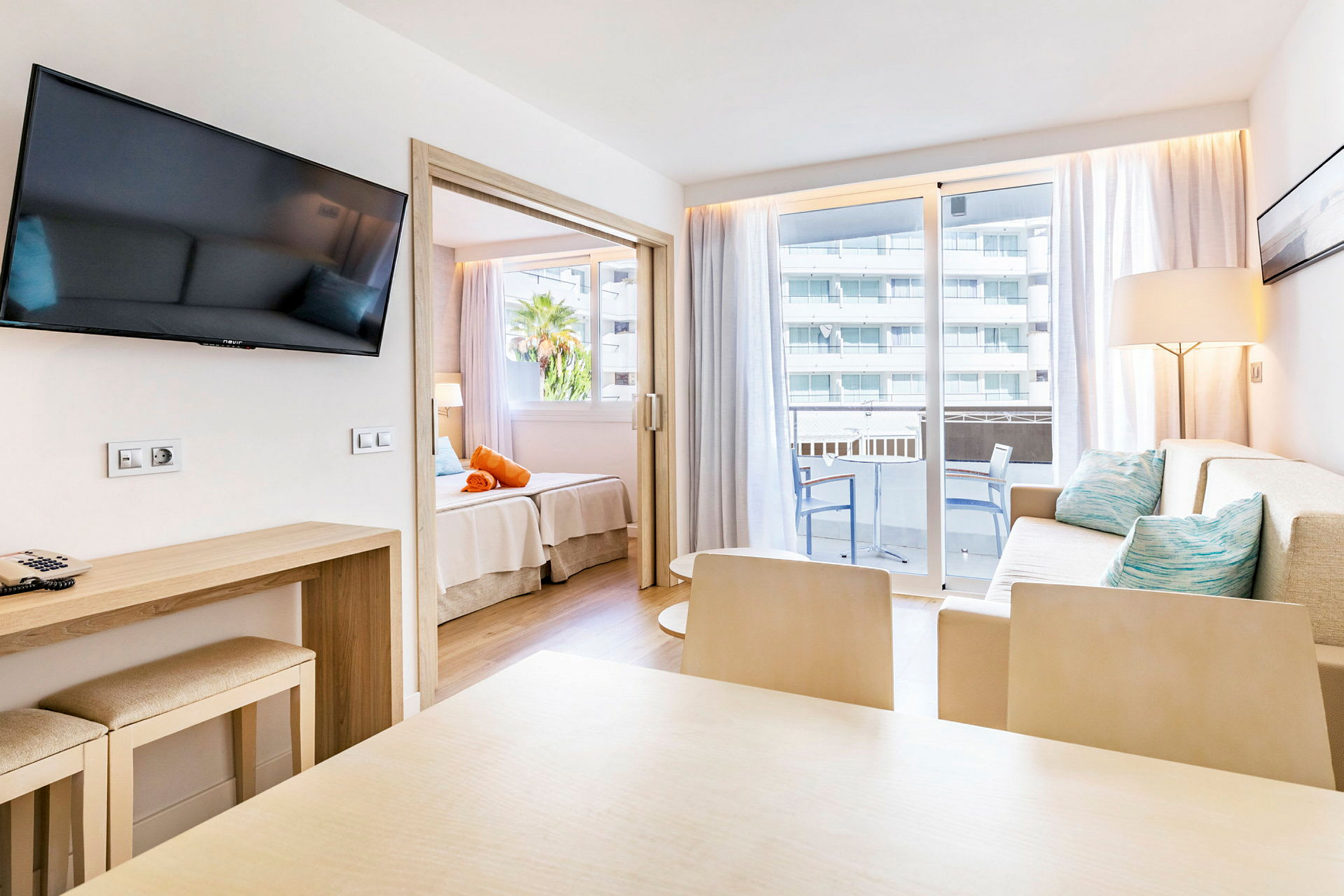 Moderne hotellrom med sittegruppe, spisebord, balkong og sovedel. (AI-generert tekst)