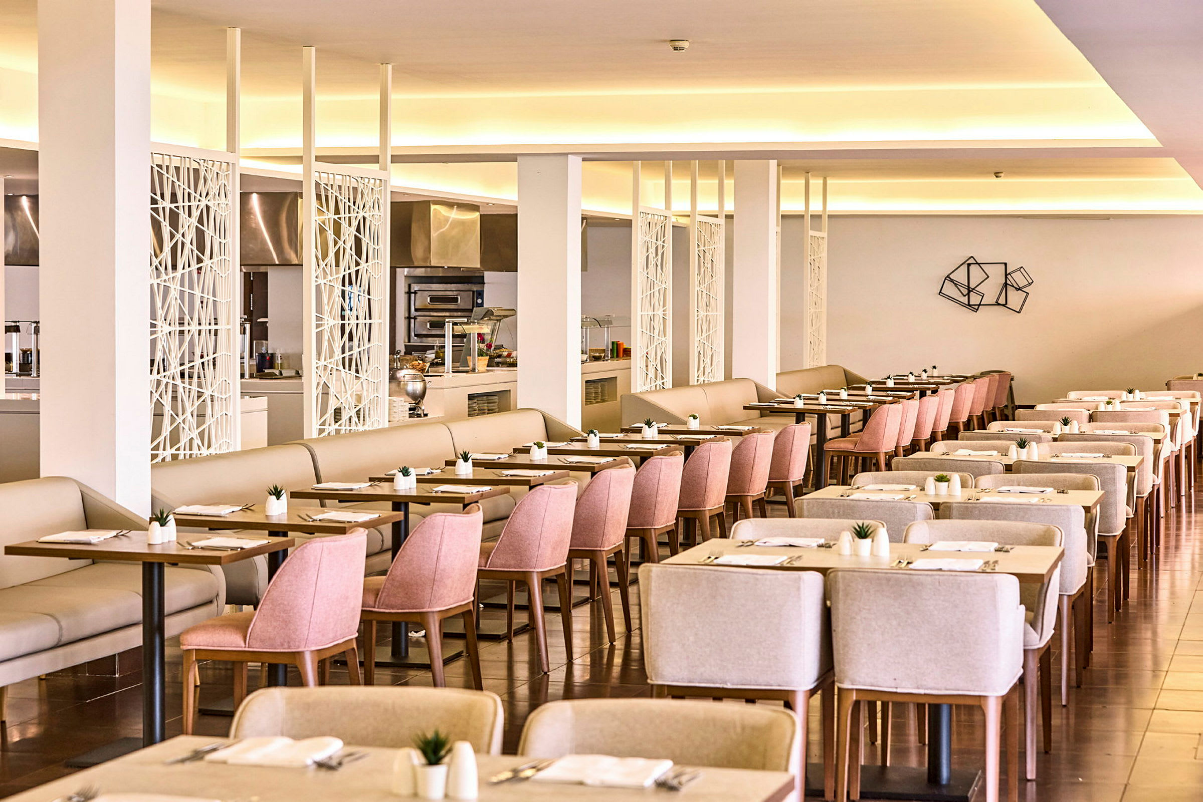 Et romslig hotellrestaurantområde med lys innredning og velordnede bord og stoler. (AI-generert tekst)