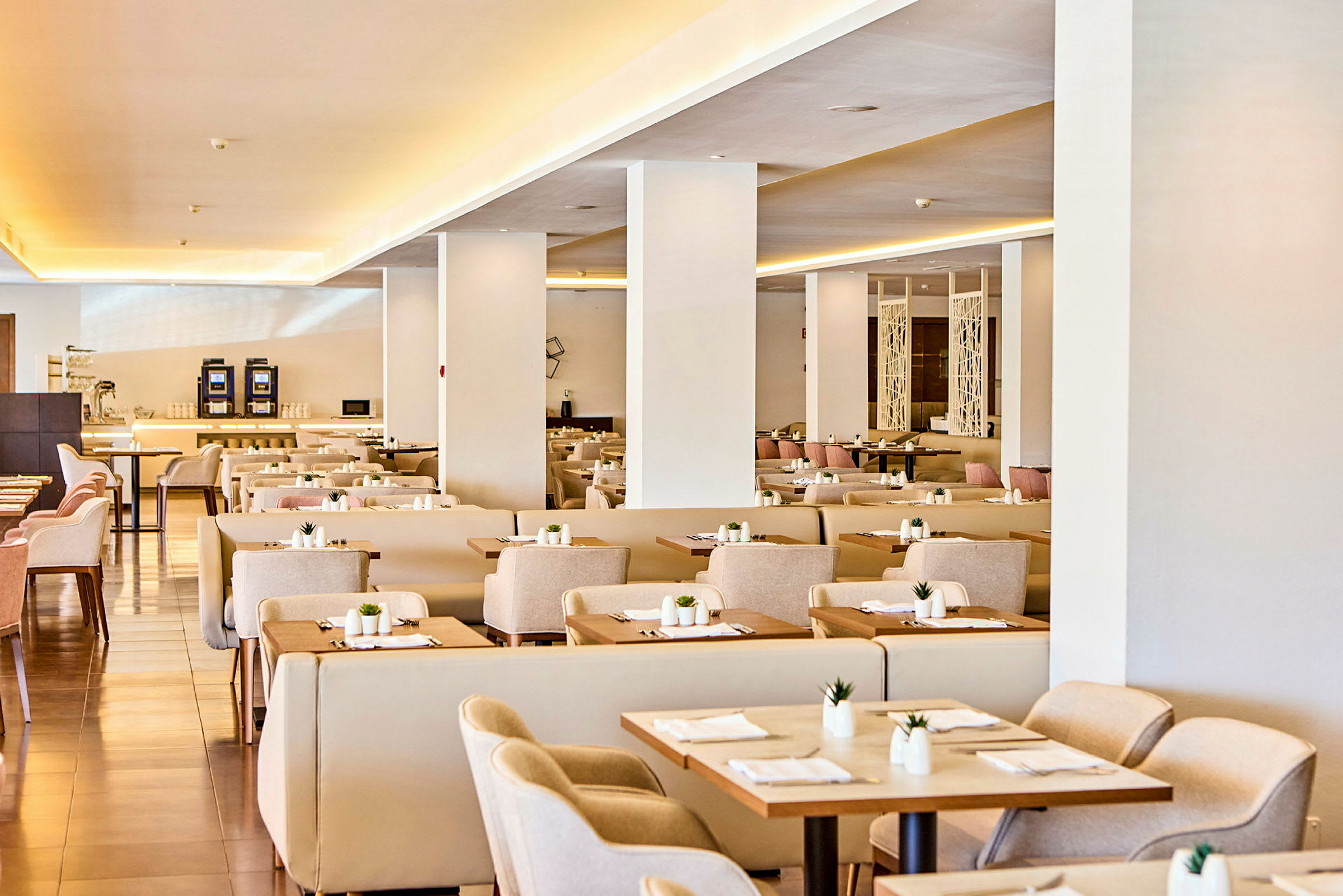 En elegant restaurant med ferdigdekkede bord og beige stoler. (AI-generert tekst)
