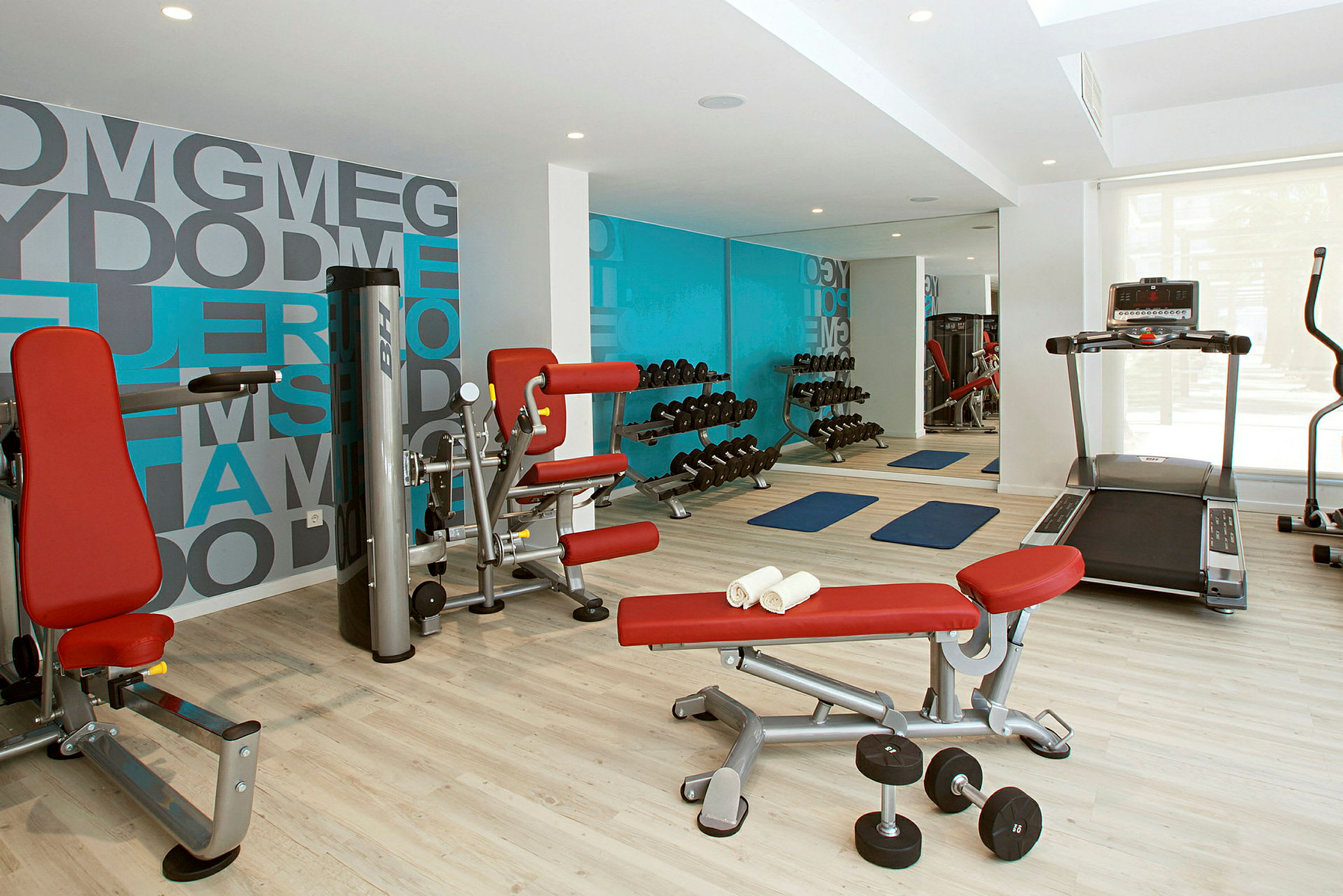 Et treningsstudio med treningsapparater, manualer og yogamatter. (AI-generert tekst)