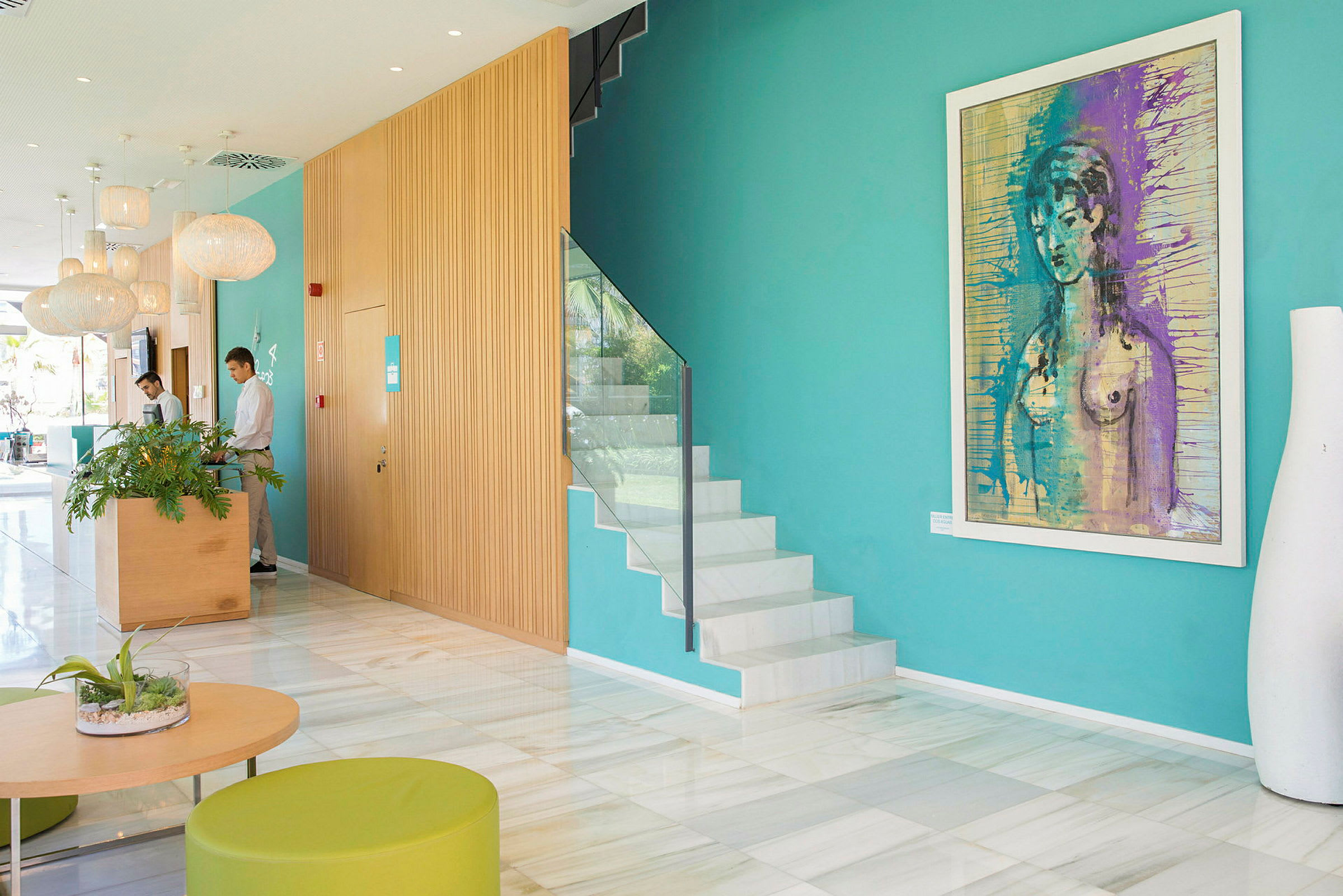 Hotellets elegante lobby med fargerik kunst på veggene og moderne møbler. (AI-generert tekst)