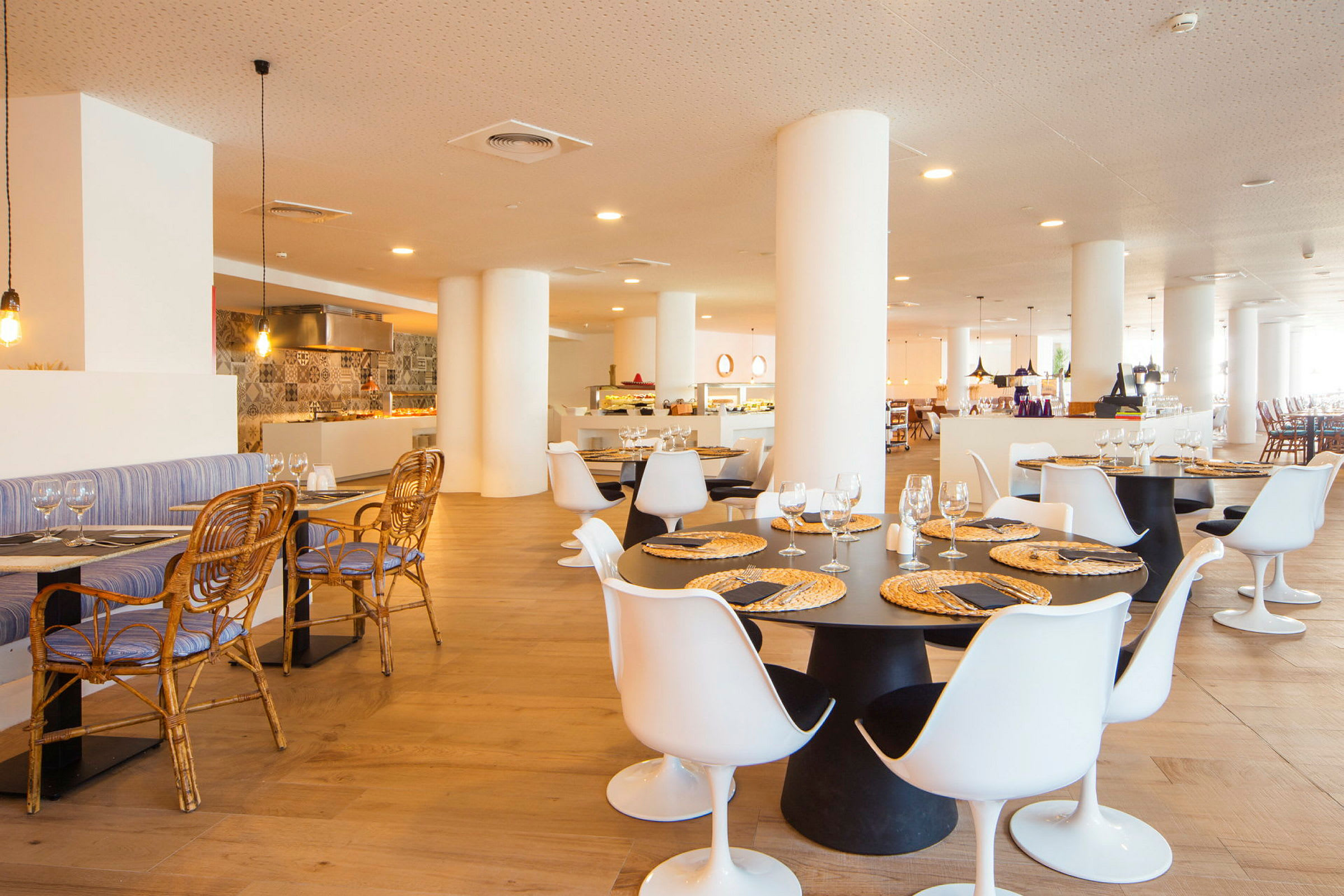 Restaurant med sitteplasser, bord og dekorativ belysning. (AI-generert tekst)