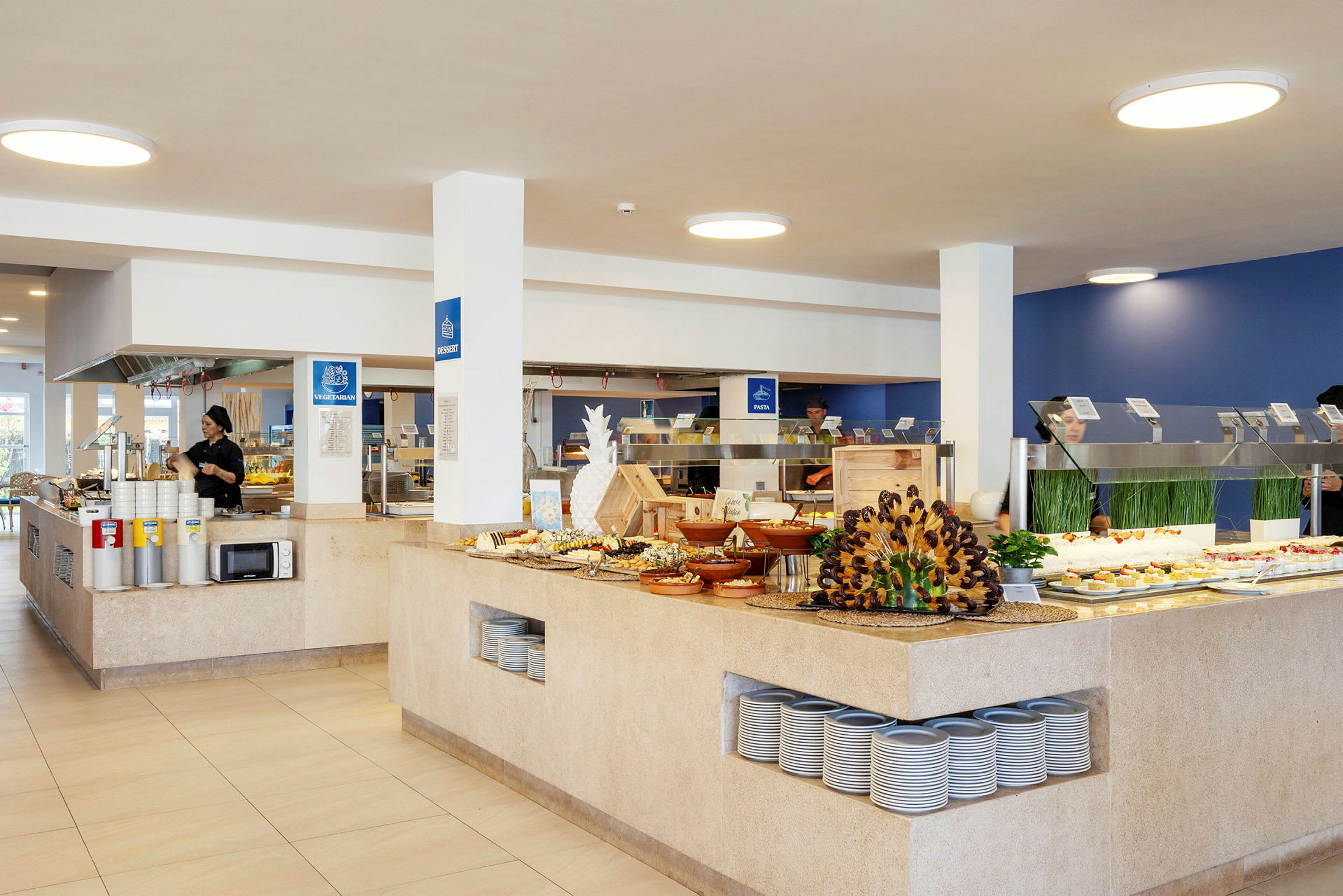 Et buffetområde i en moderne matservering med forskjellige retter utstilt på bord og hyller. (AI-generert tekst)