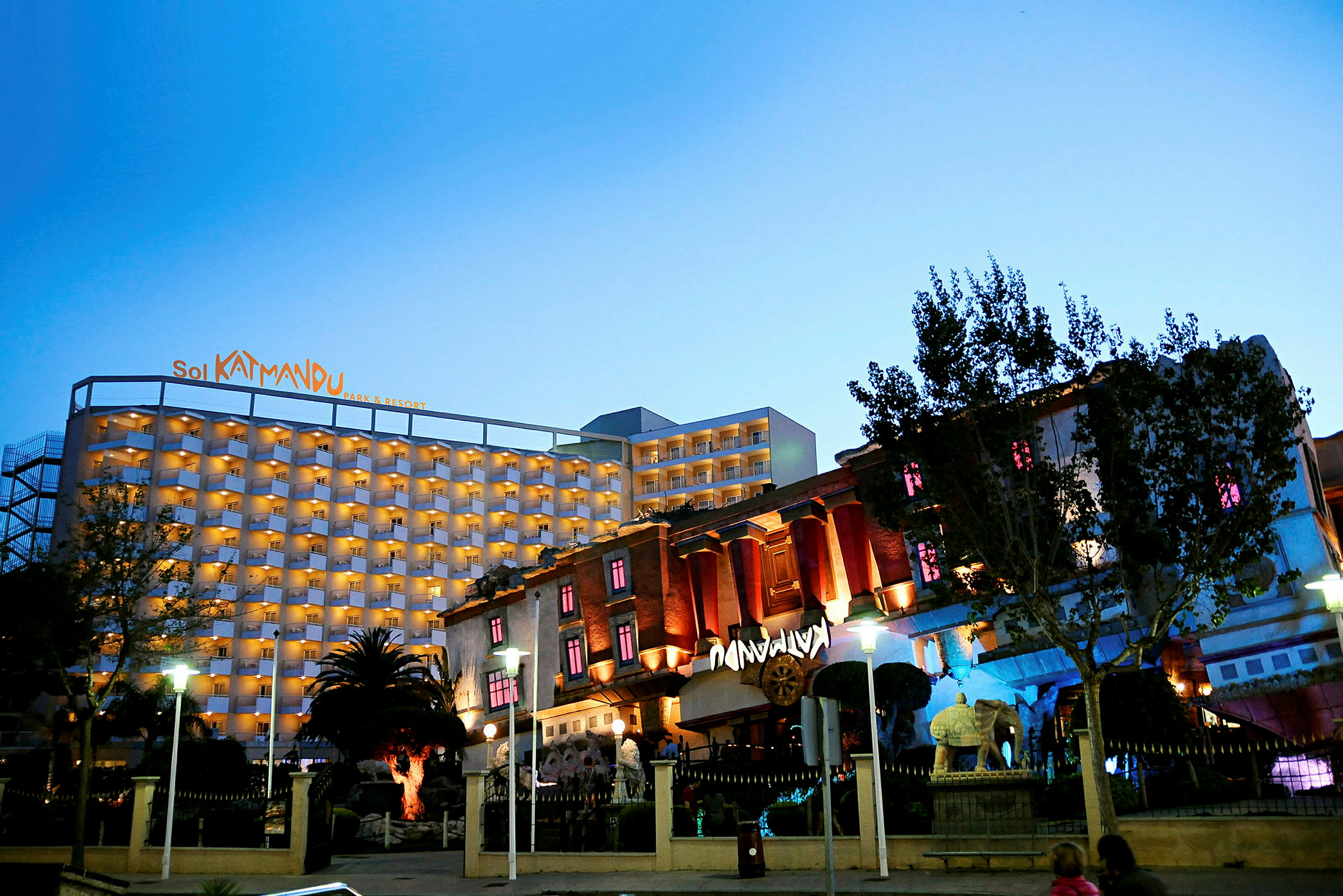 Et hotell med navnet Sol Katmandu Park & Resort, opplyst om kvelden, omgitt av en hage. (AI-generert tekst)