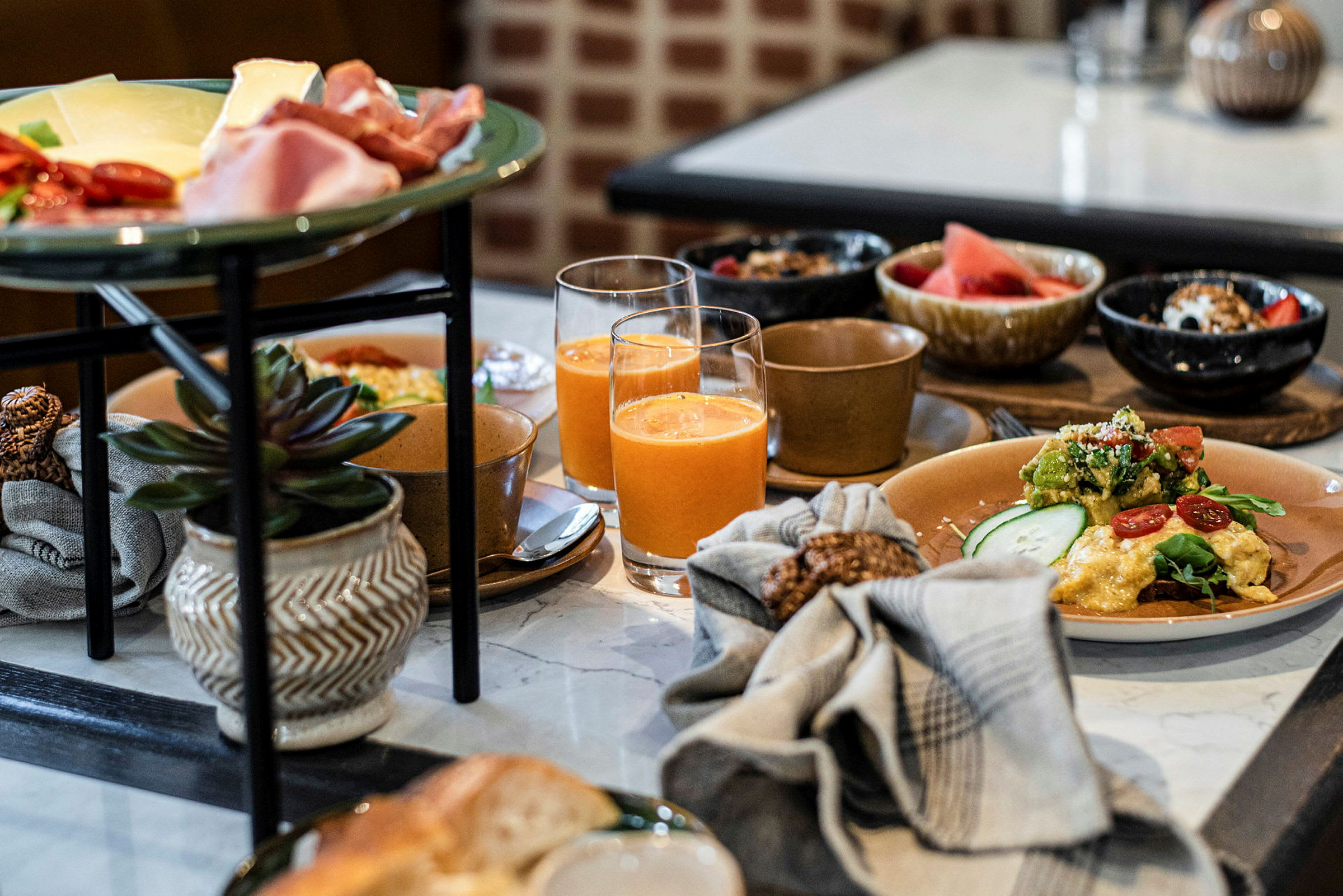 En frokostbuffé med forskjellige retter og drikker på et bord. (AI-generert tekst)