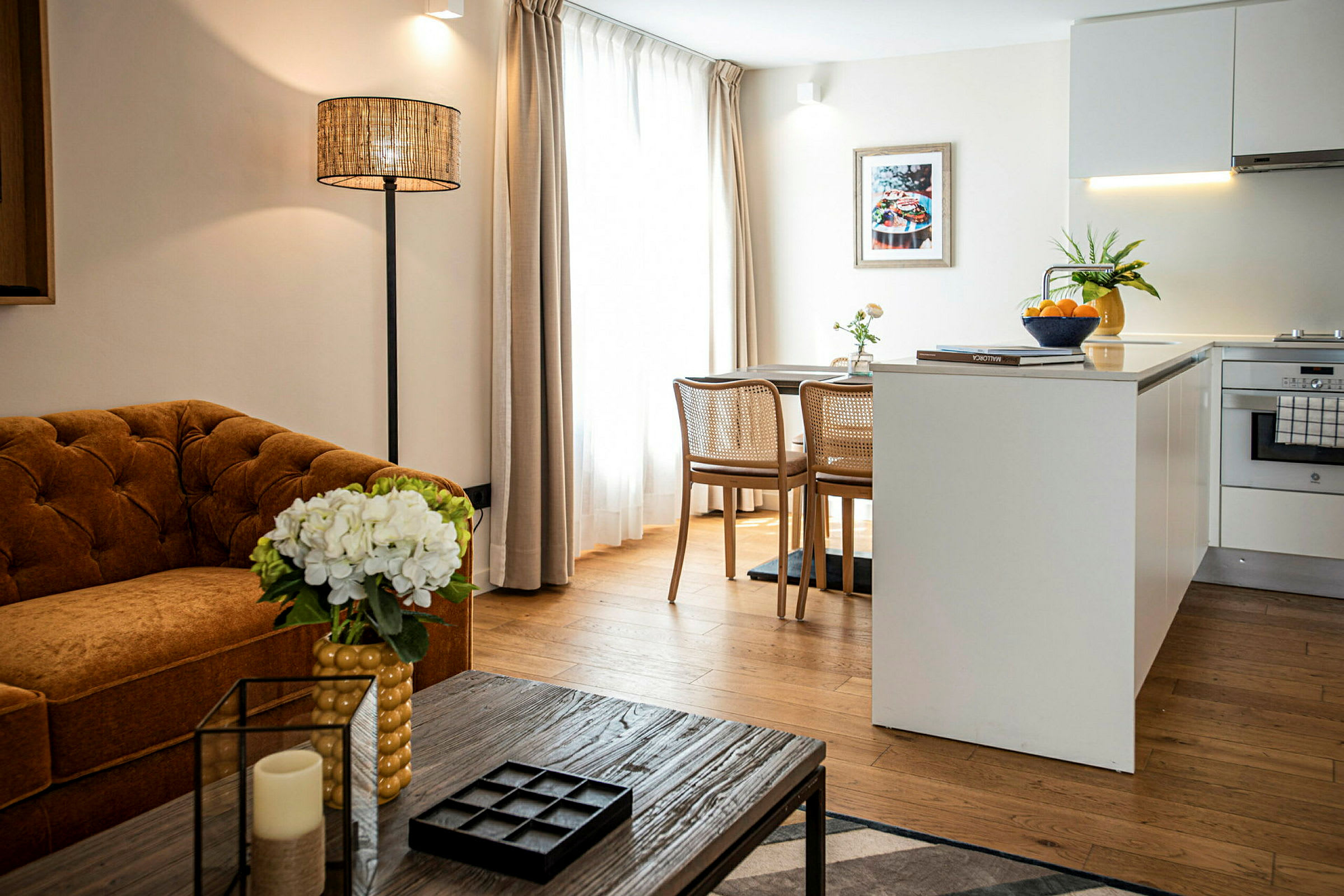Bilde av en moderne innredet stue med sofa, bord og kjøkkenøy. (AI-generert tekst)
