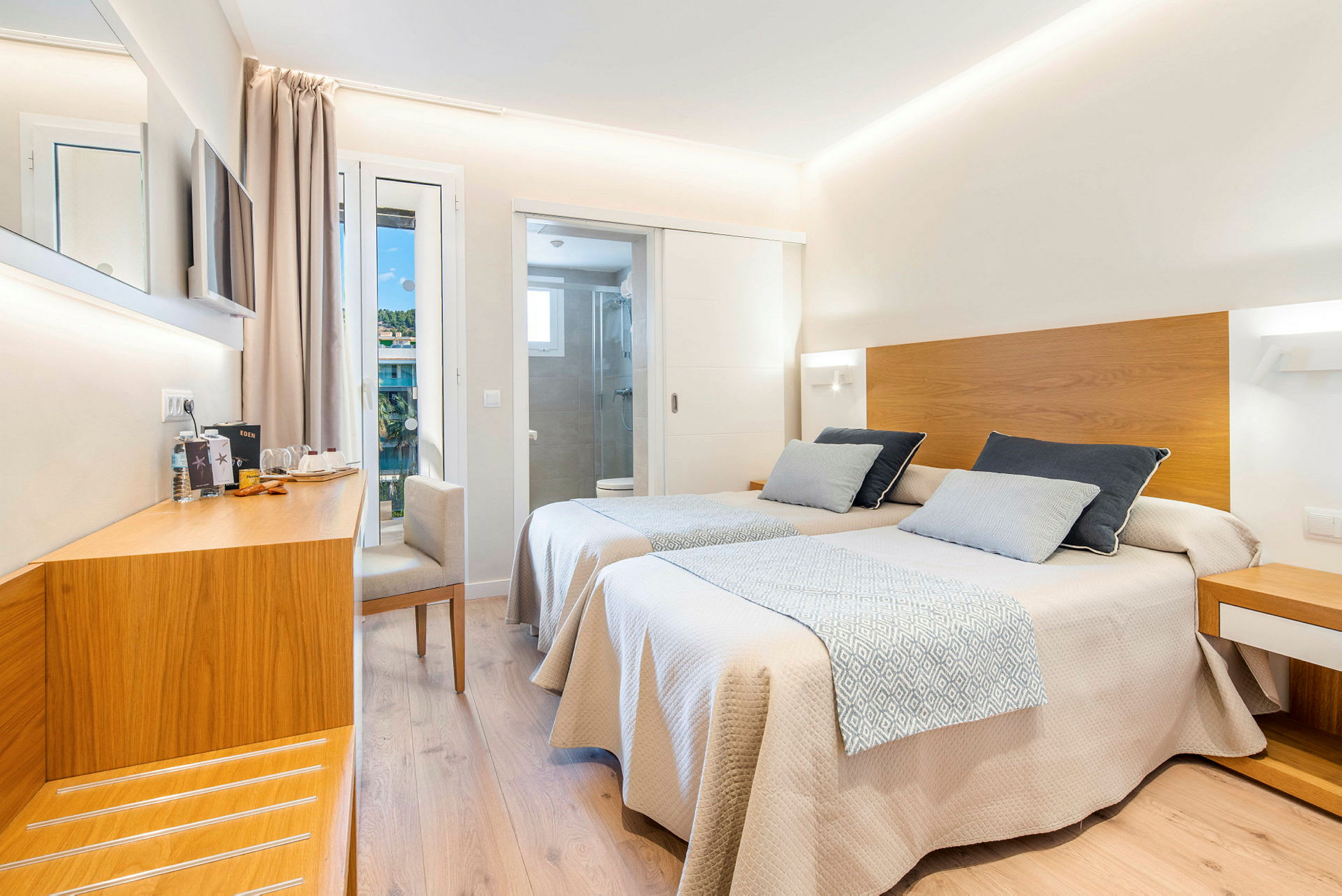 Et hotellrom med to enkeltsenger med tredetaljer, en arbeidsplass og adskilt bad. (AI-generert tekst)