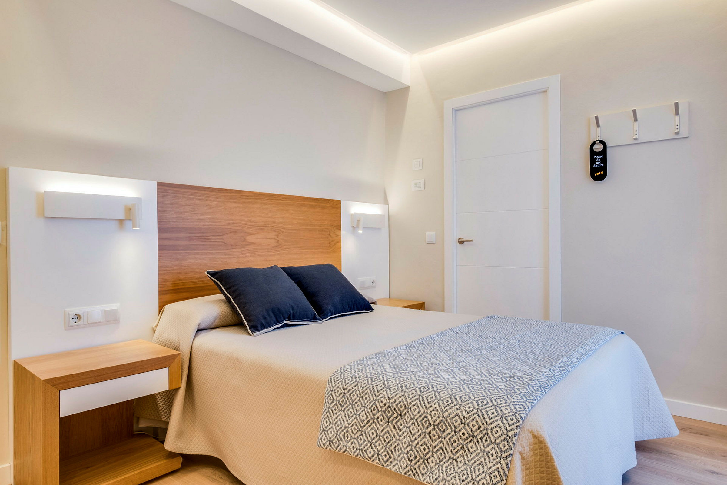 Et hotellrom med en seng og to puter. (AI-generert tekst)