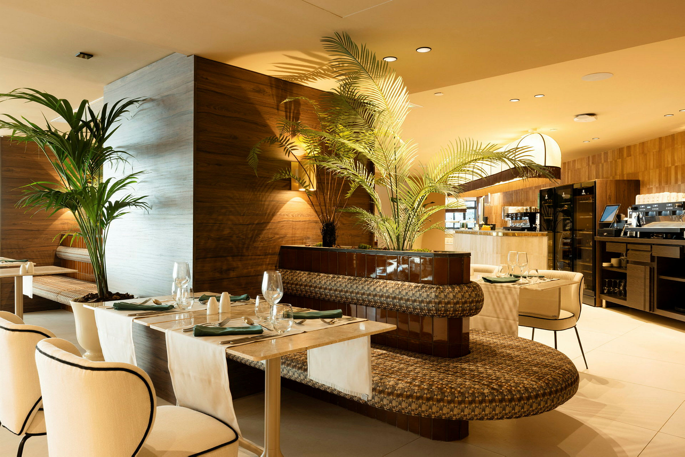 Bilde som viser en elegant restaurant med bord, stoler og dekorative planter. (AI-generert tekst)