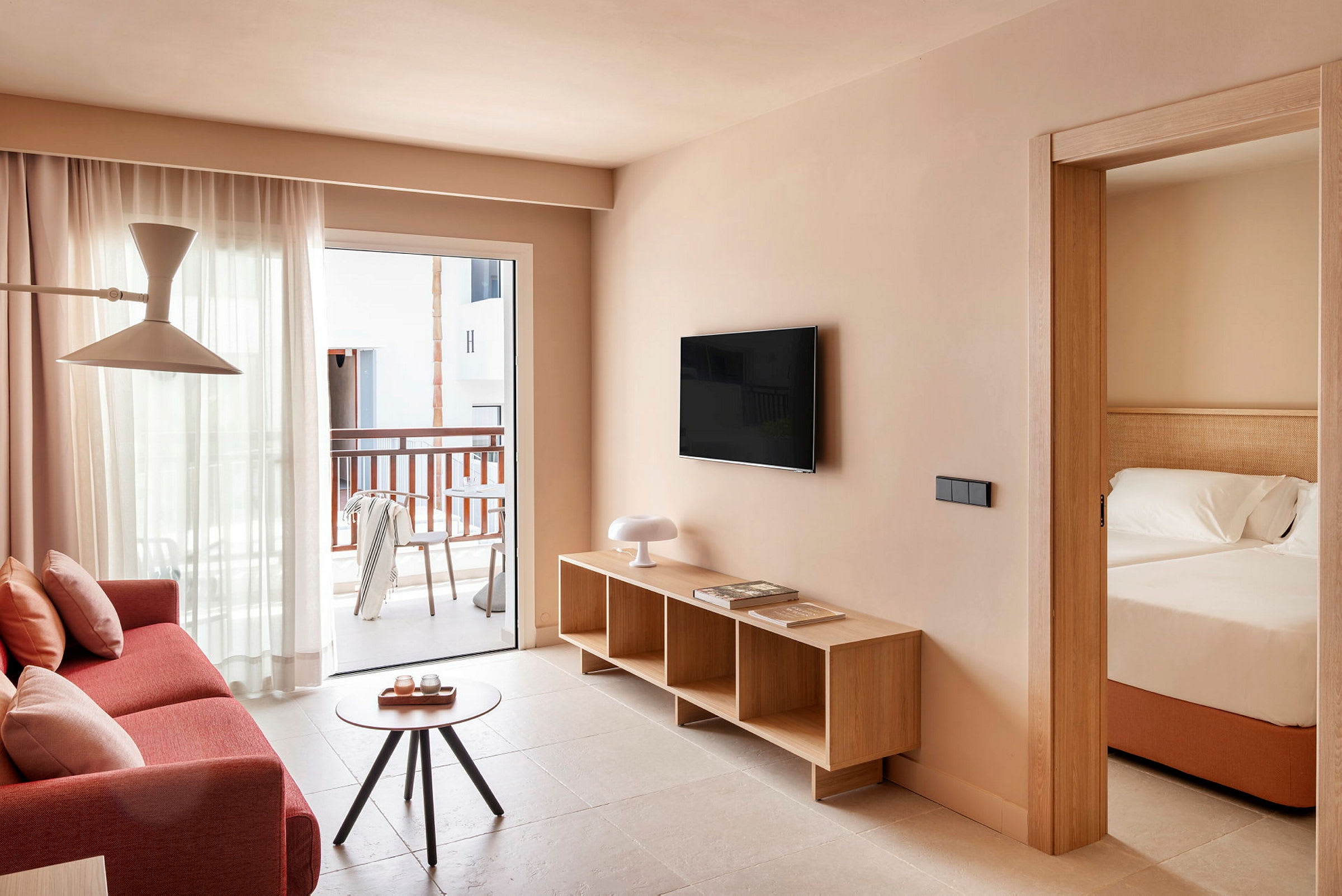 En lys og moderne hotellromsuite med stue og tilknyttet soverom. (AI-generert tekst)
