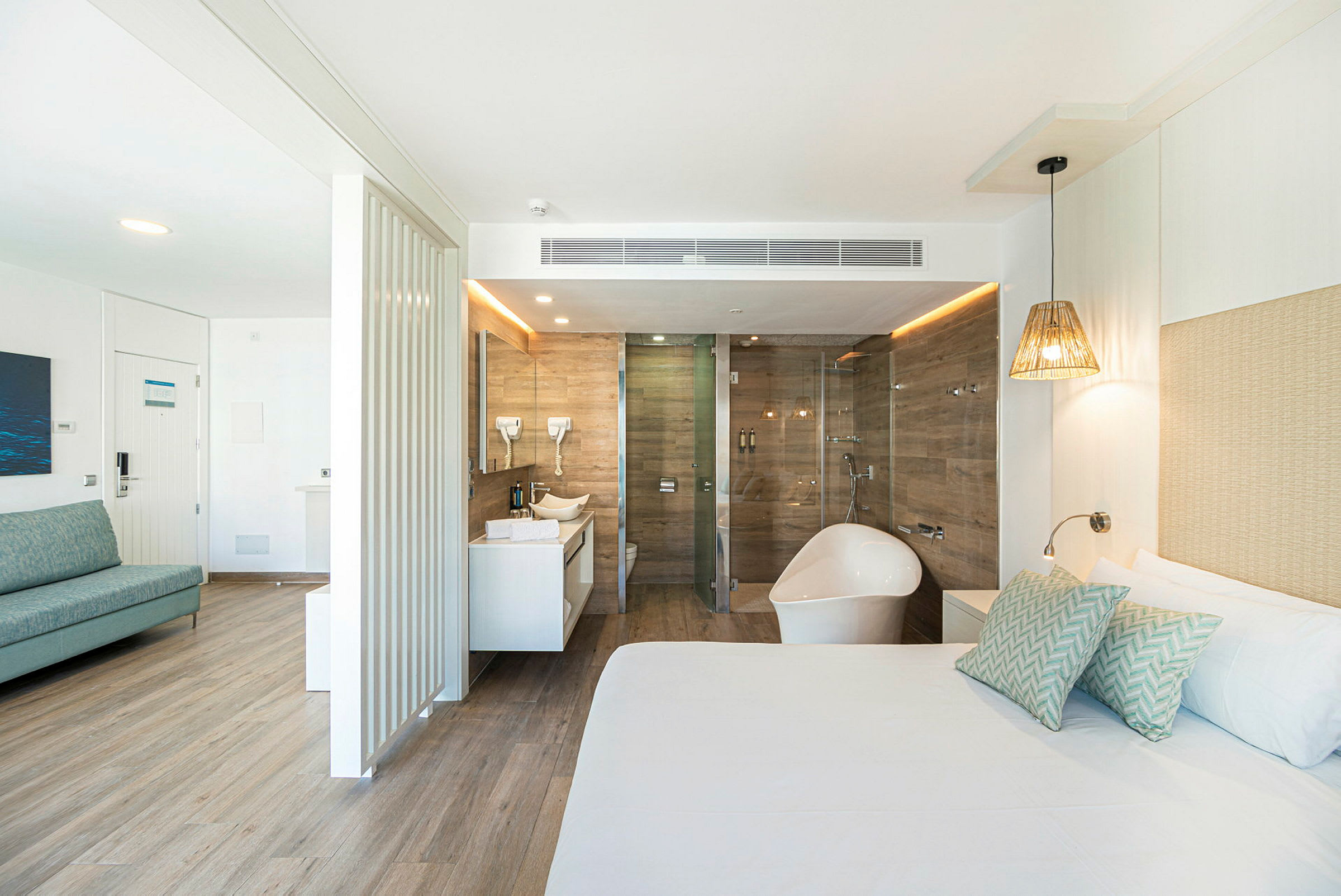 Et lyst hotellrom med badekar og dusj i tilknytning. (AI-generert tekst)
